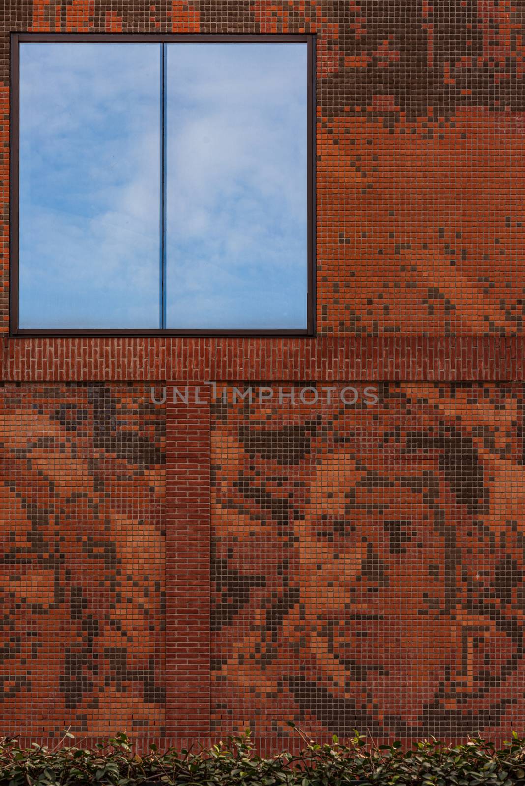 Building facade with a glass window on which a blue sky is reflected, street photography