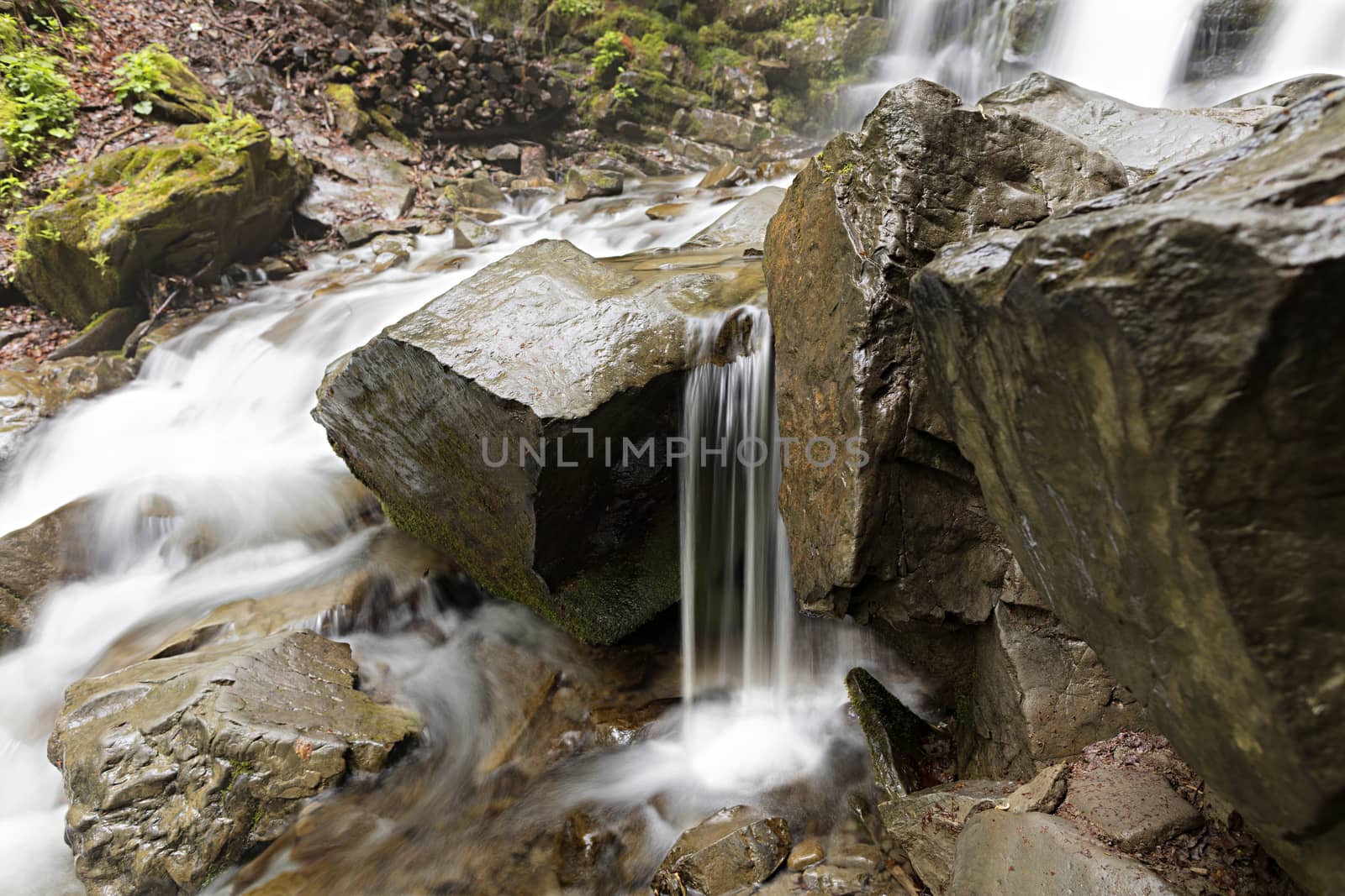 Large stones boulders washed by water in the mountain stream of the river, close-up