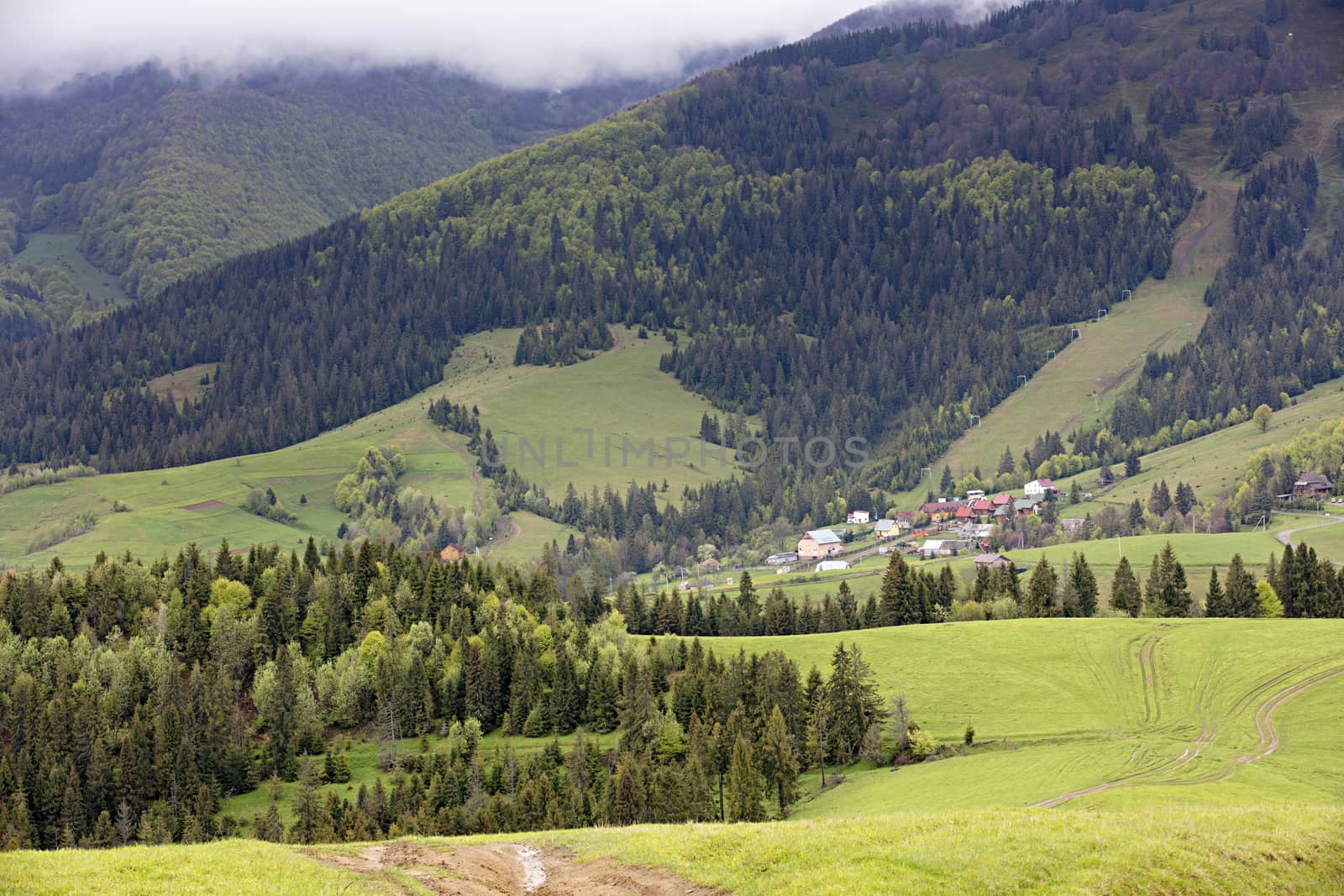 In the valley of the Carpathian mountains among coniferous forests sheltered a village with a mountain lift