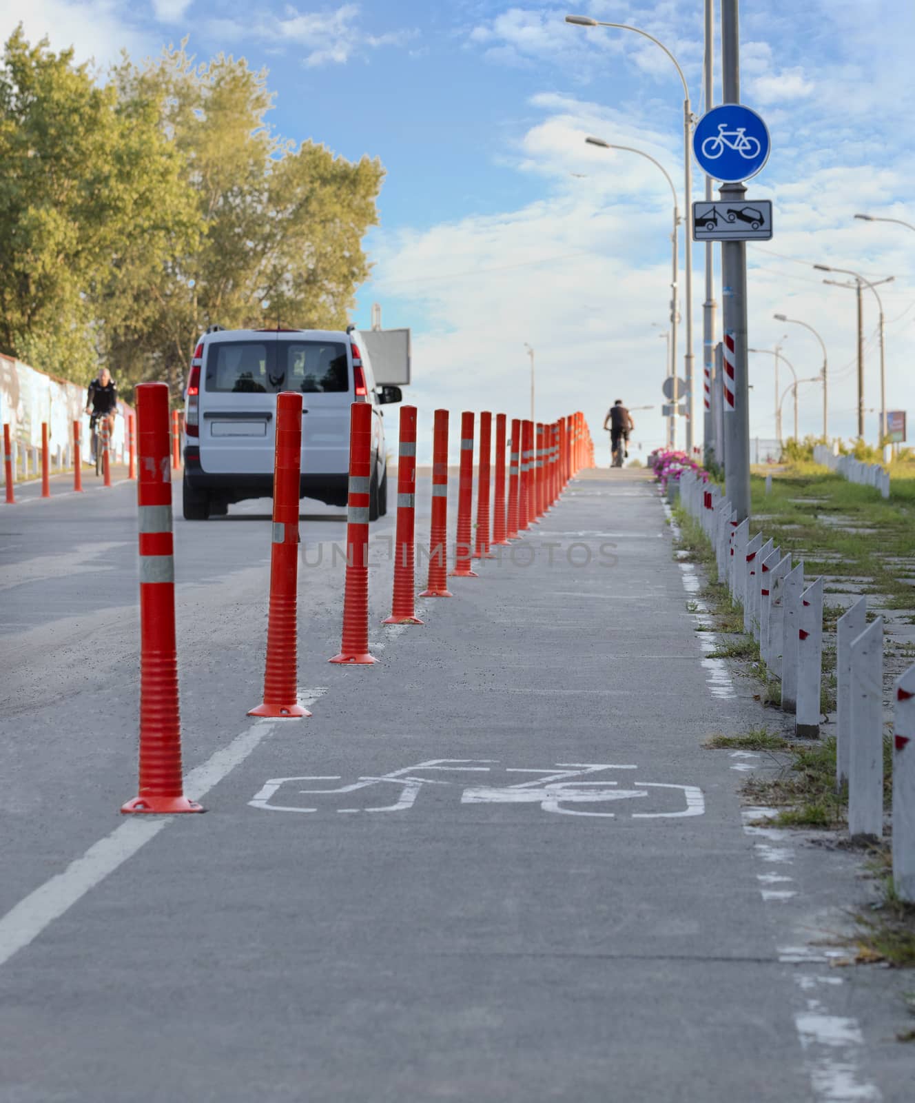 bike path in the park fenced with red road columns by Sergii