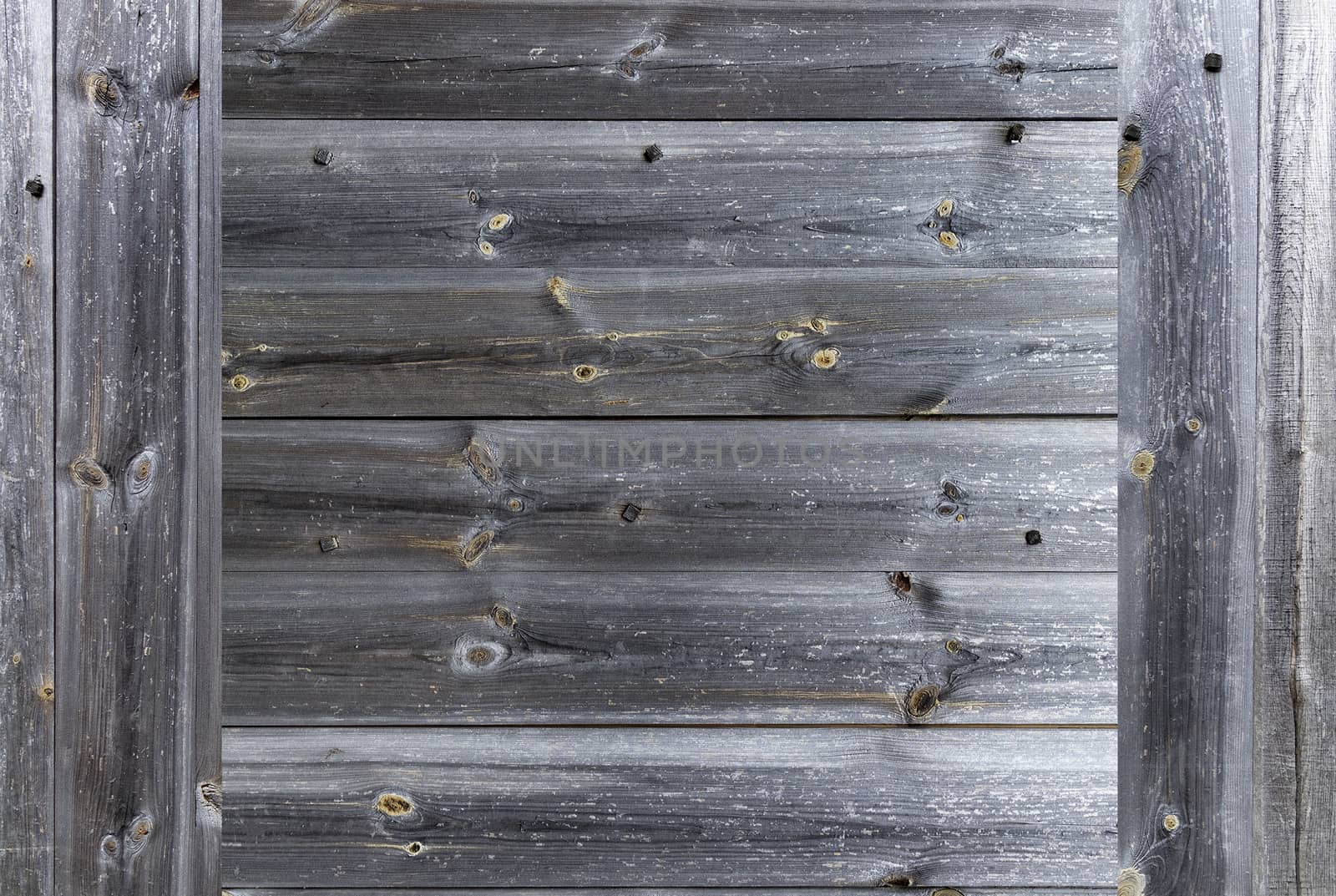 A frame in the form of a weathered old gray wooden fence, which is knocked down by wooden nails, close-up