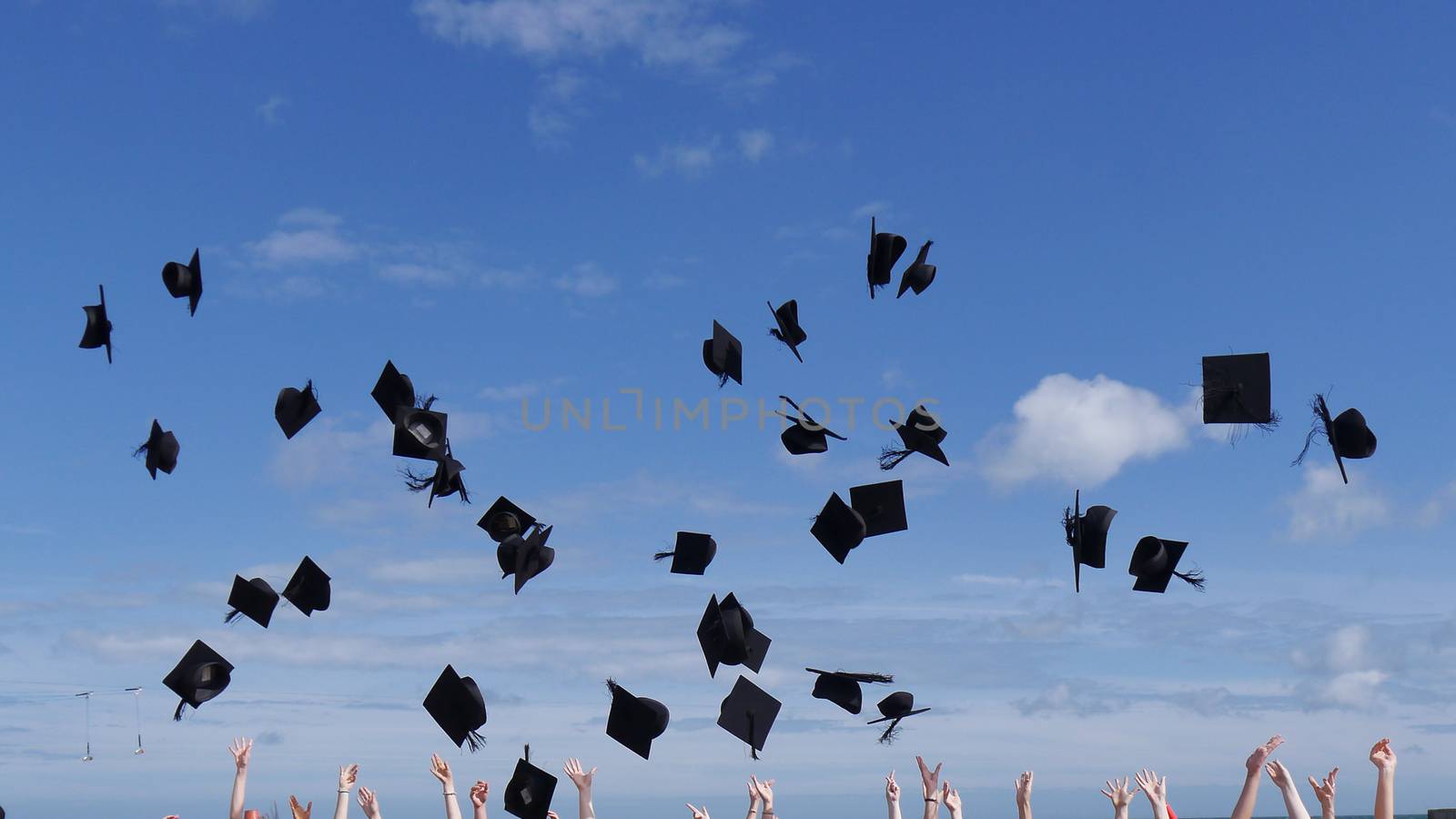 university graduates caps being thrown into the air to celebrate the award of their degrees