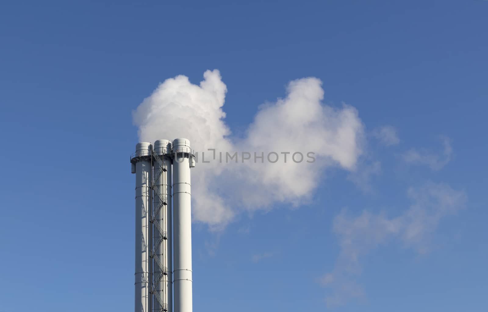 White smoke comes from a white chimney pipe on a background of blue sky. by Sergii