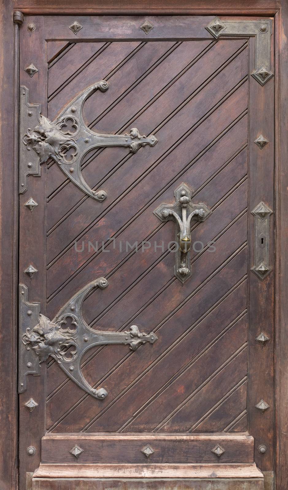 Ancient antique wooden doors with wrought iron loops and cross bars. by Sergii