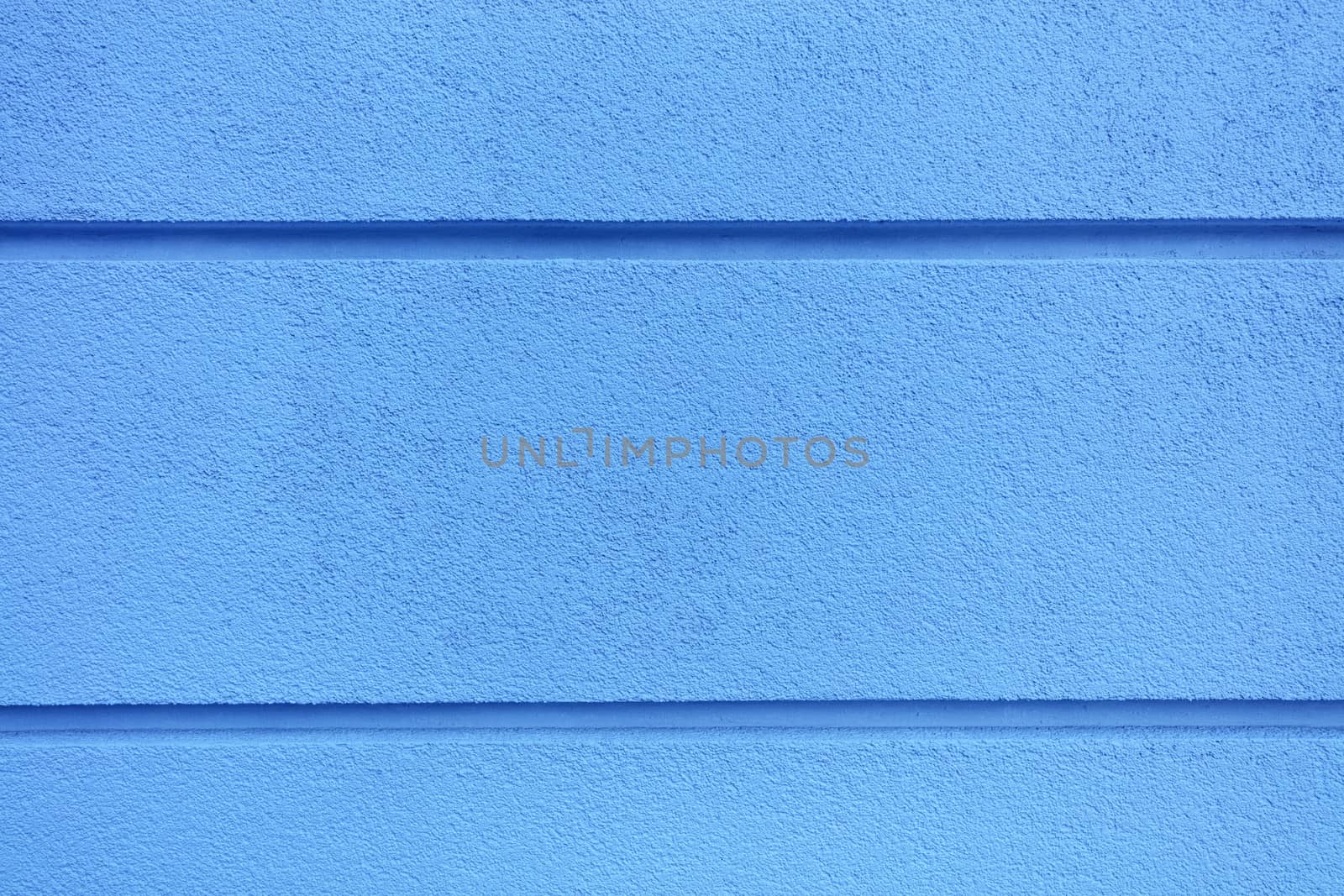 Concrete wall texture with colored bright blueplaster. Construction coat-plaster made of insulated material on the wall with horizontal dividing grooves.