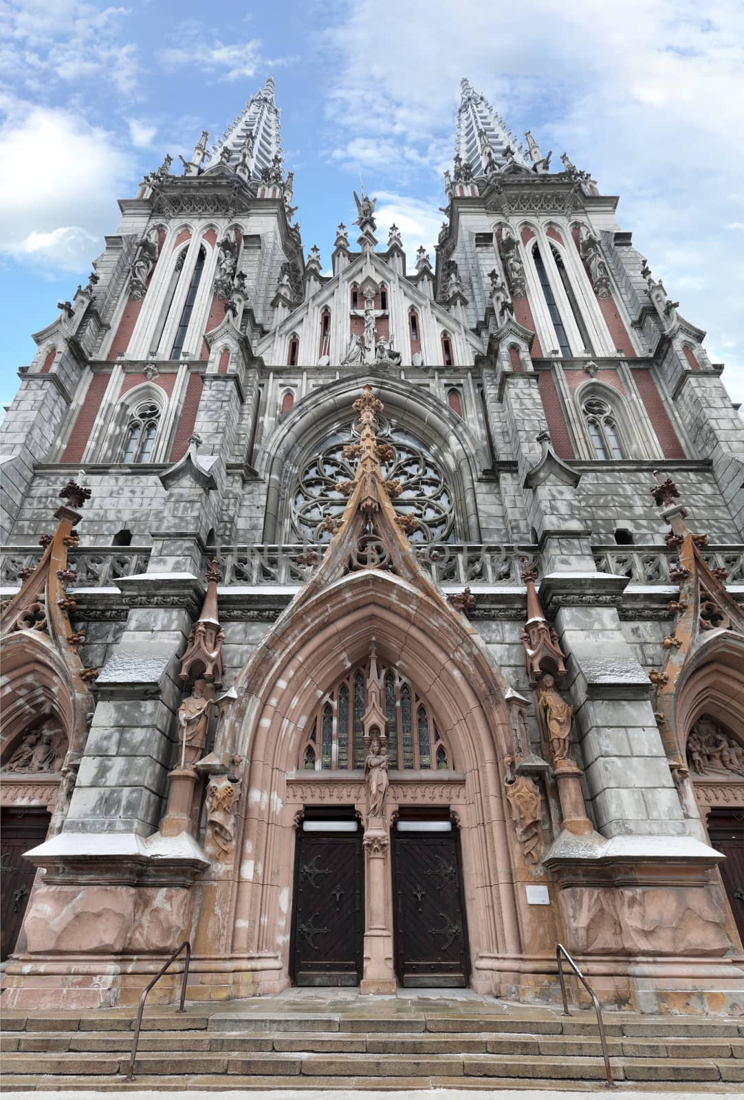 The facade of the Roman Catholic Cathedral of St. Nicholas in Kiev against the blue sky and white clouds, February 2018, Ukraine.