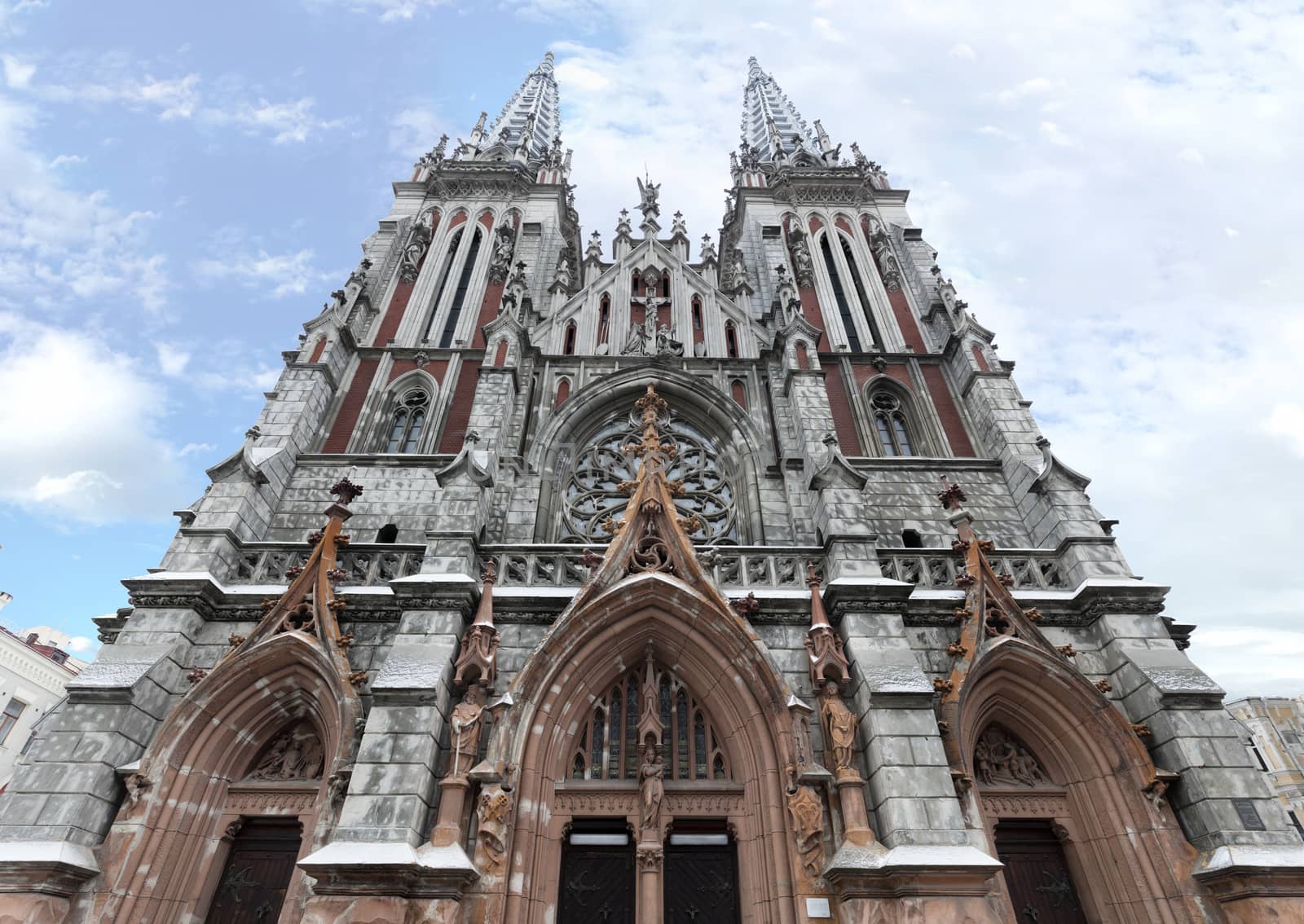The facade of the Roman Catholic Cathedral of St. Nicholas in Kiev against the blue sky and white clouds, February 2018, Ukraine.