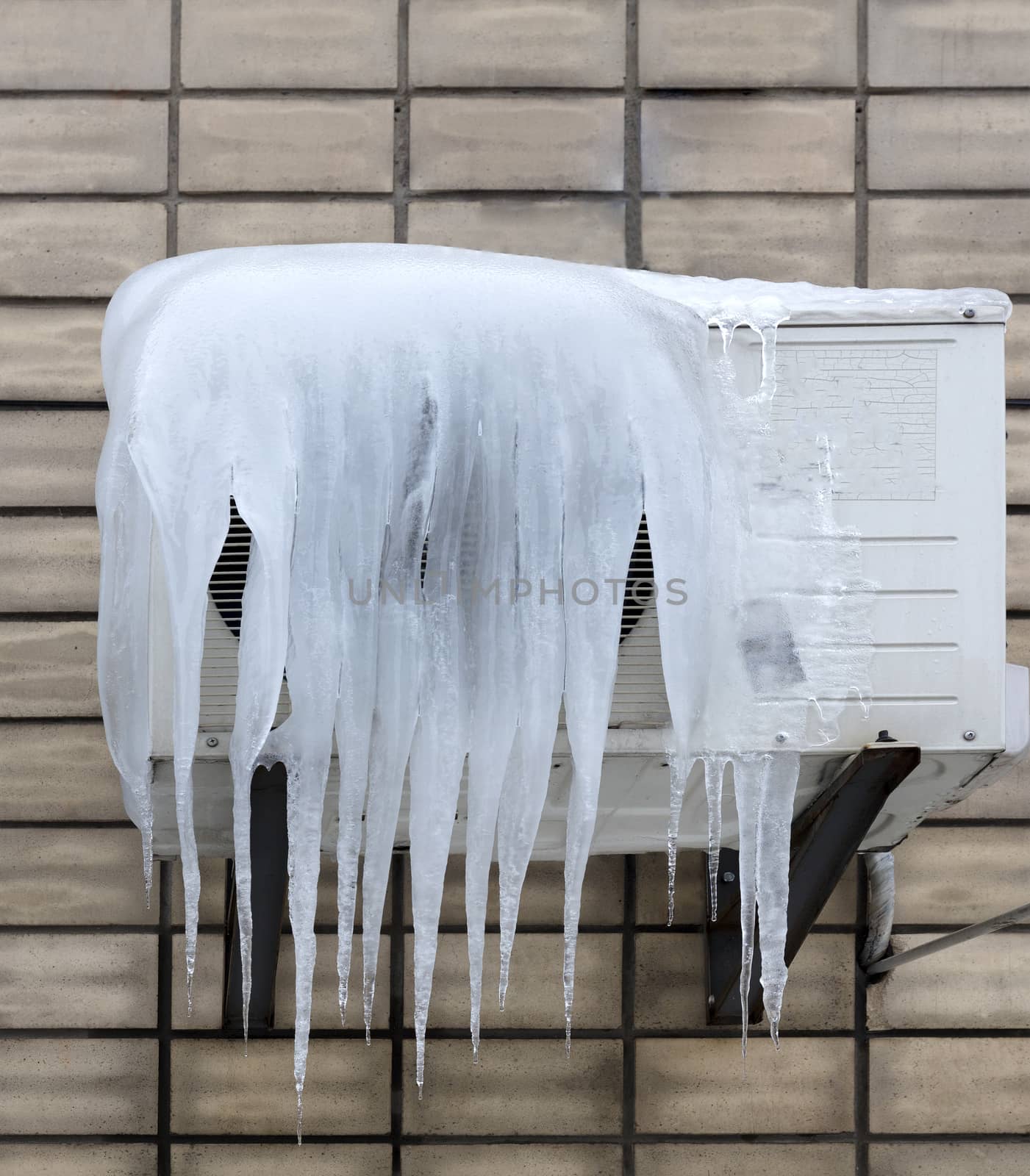 the external unit of the air conditioner is covered with large icicles. Incorrect use of the air conditioner and poor thermal insulation leads to the formation of icicles.