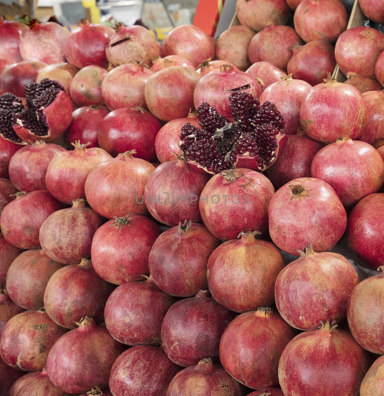 Ripe and red fruit pomegranate and divided into four parts, against the background of pomegranate fruit by Sergii