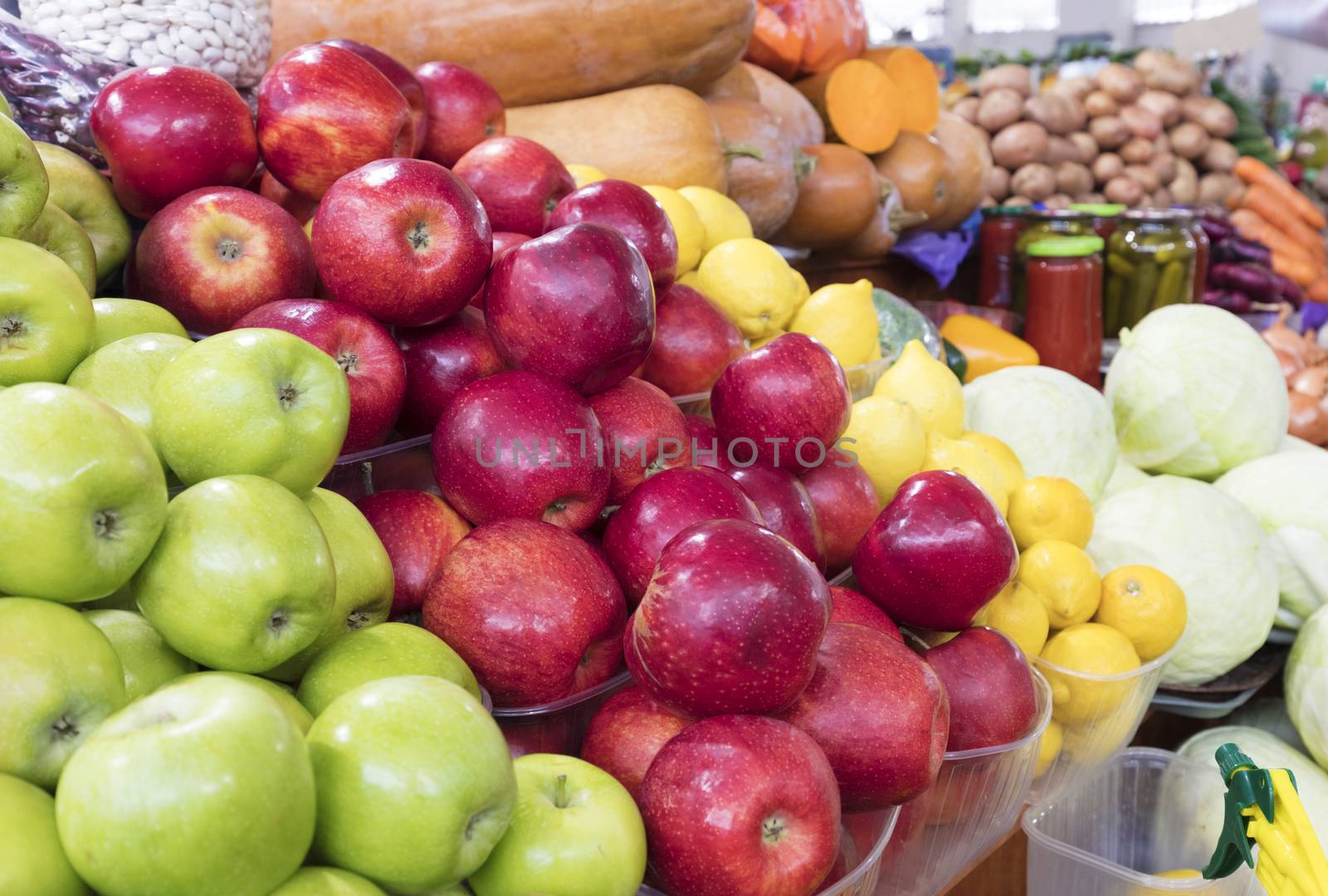 Bright background of fresh fruits. Apples, lemons lie in the trays in the market and attract attention.