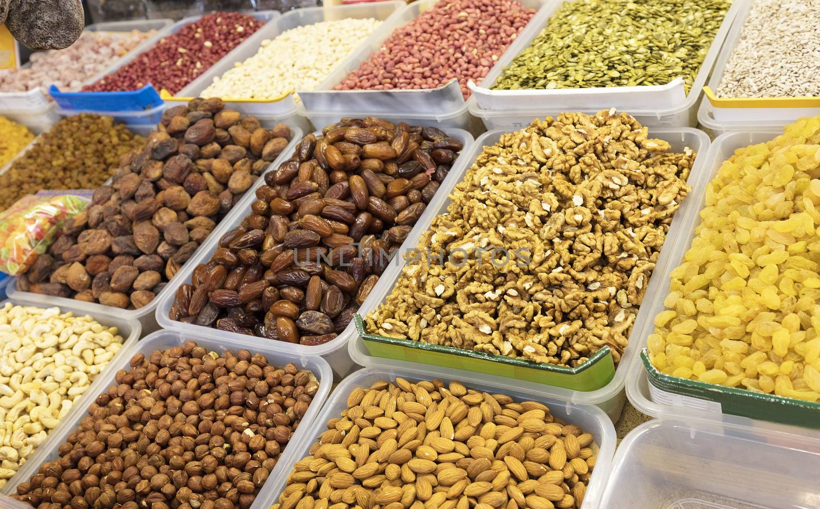 Ingredients for healthy vegetarian food are nuts and dried fruits on trays. Walnut, pecans, almonds, hazelnuts, dates, cashew nuts, pine nuts.