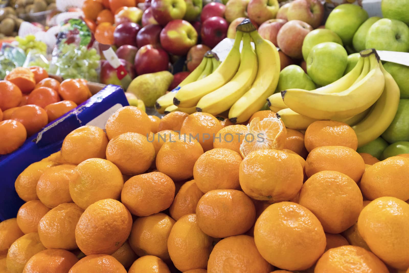 Bright background of fresh fruits. mandarins, bananas, apples lie in the trays in the market and attract attention.