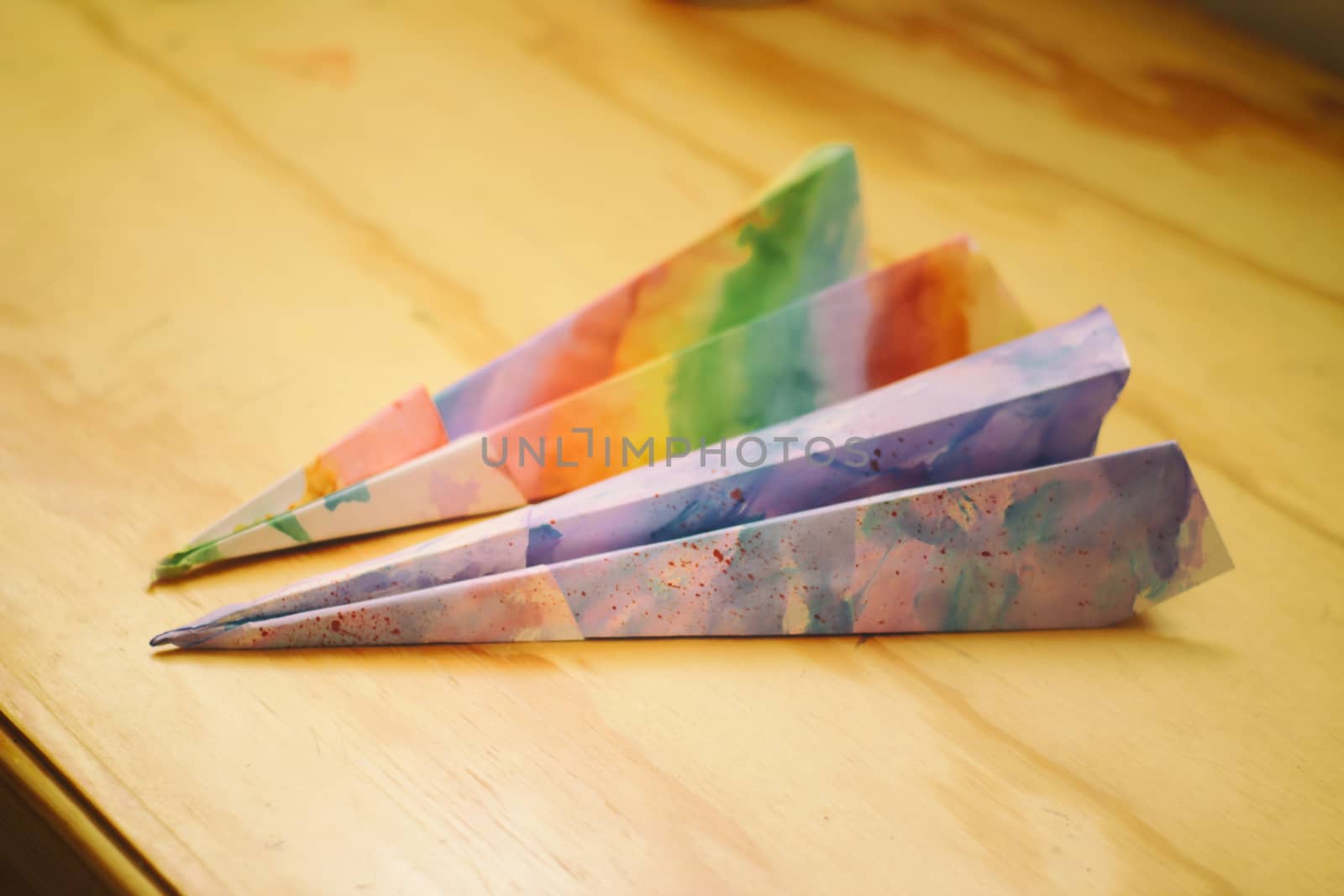 Photograph of some paper colorful planes on a wood table