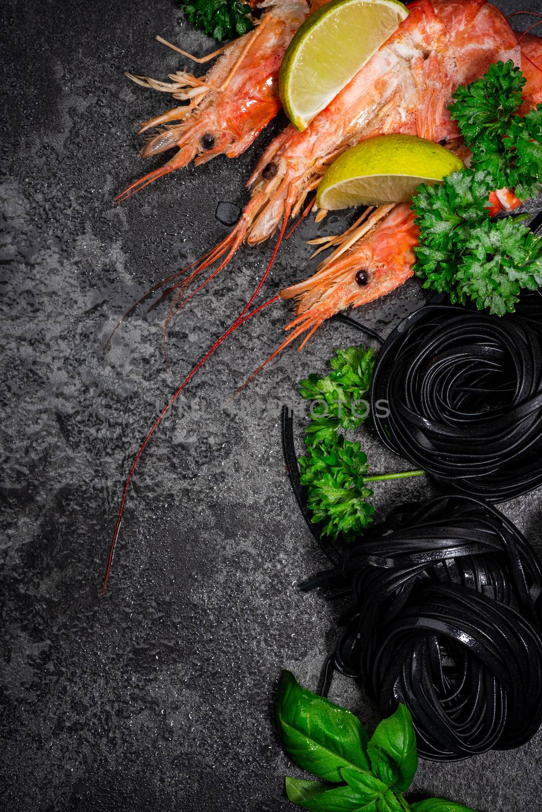 Squid Ink Black Pasta Spaghetti with Seafood and Fresh Herbs. Border Background with Copy Space. Top View.