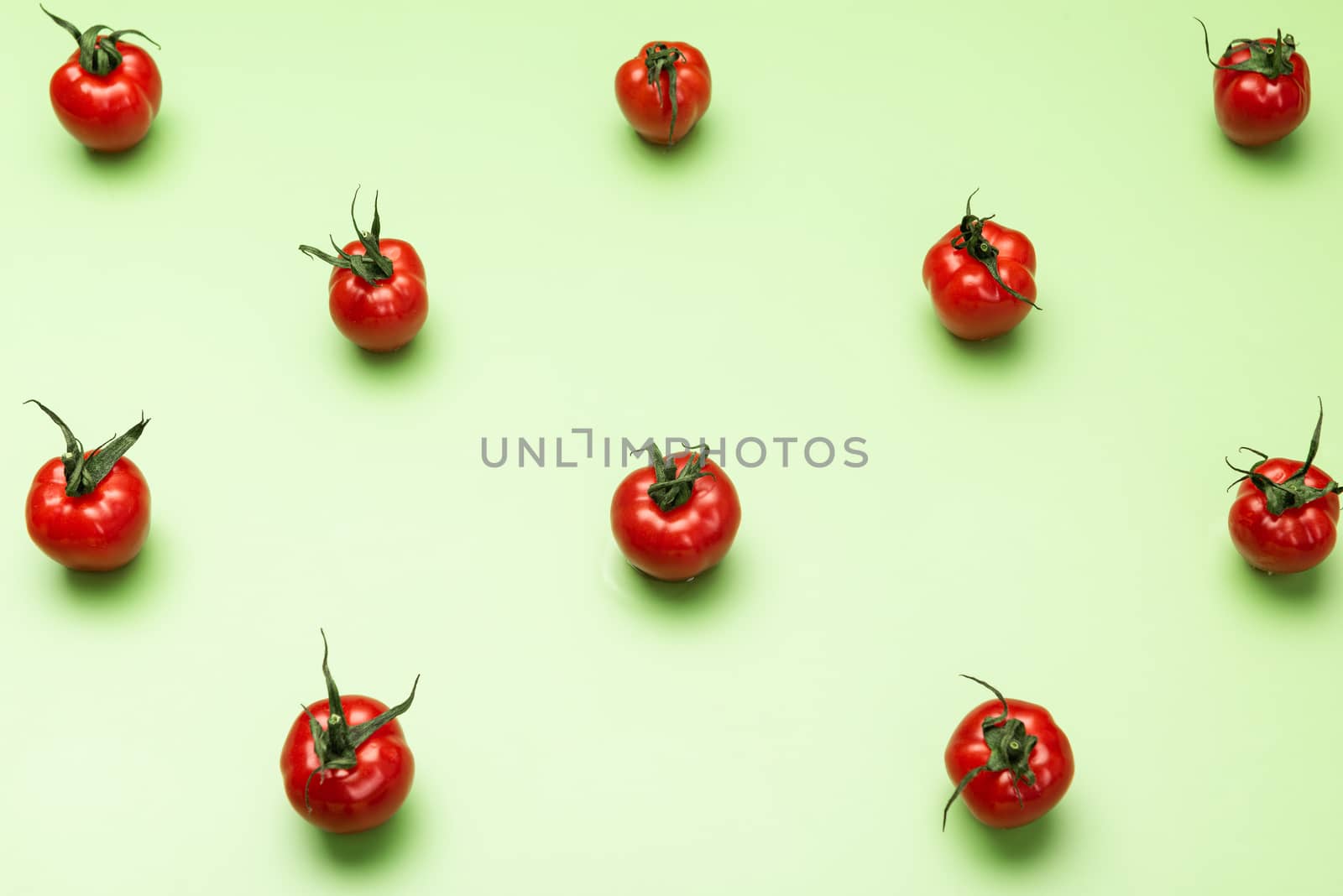 Red Tomatoes Geometric Pattern on Green Background. Flat Lay Design.