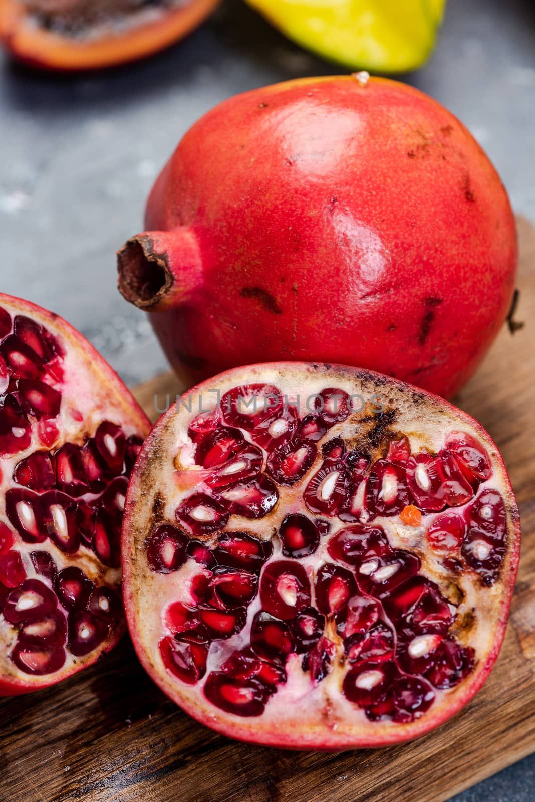 Pomegranate Tropical Fruit Cut in Half on Wooden Board by merc67