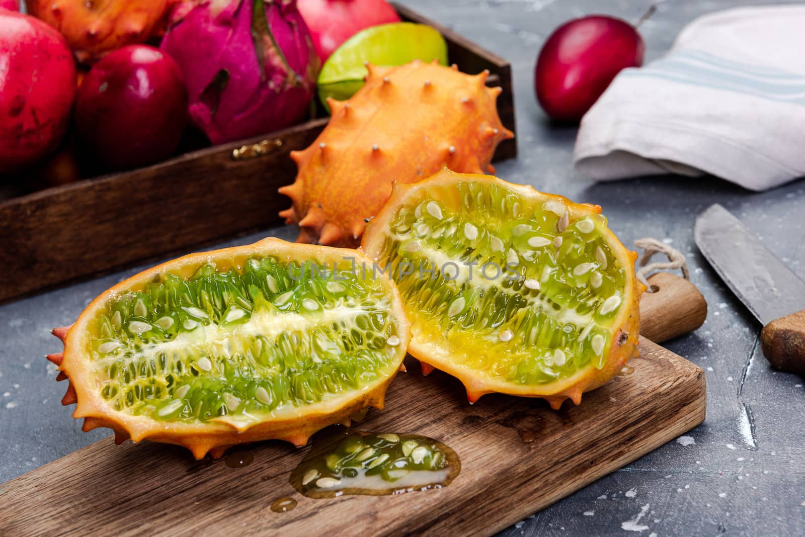 Whole and Cut Kiwano or Horned Melon Exotic Fruit on Board.