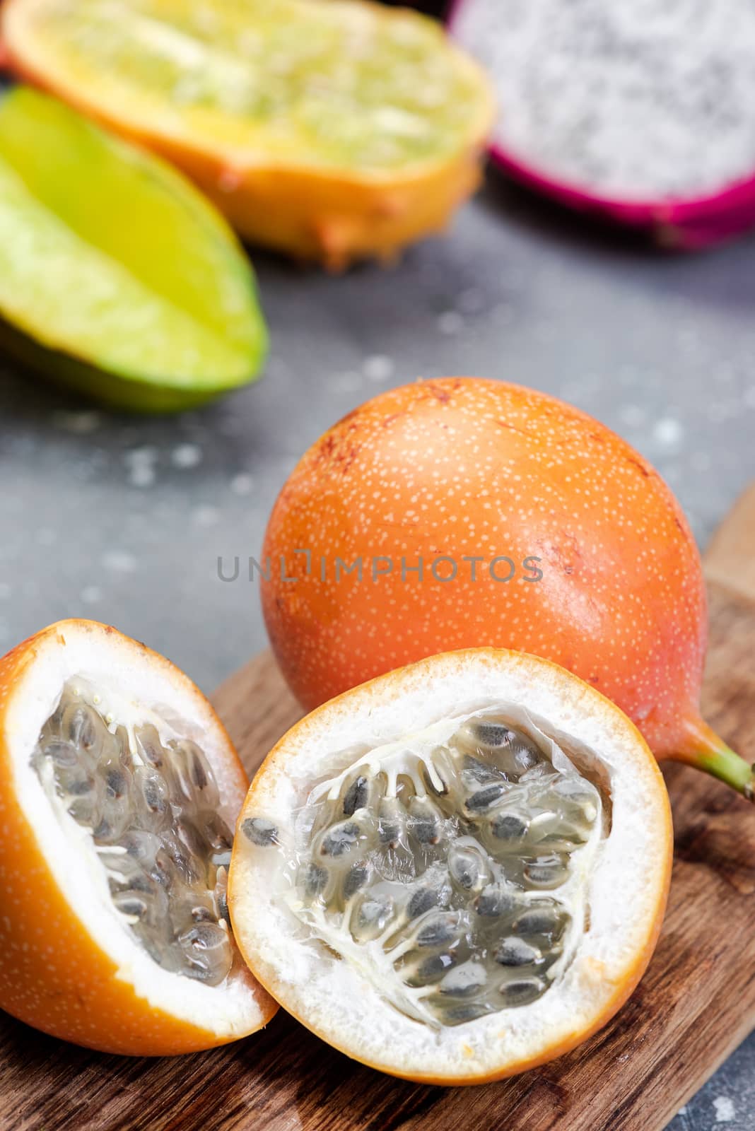 Granadilla or Grenadia Passionfruit Cut in Half Exotic Fruits on Wooden Board.