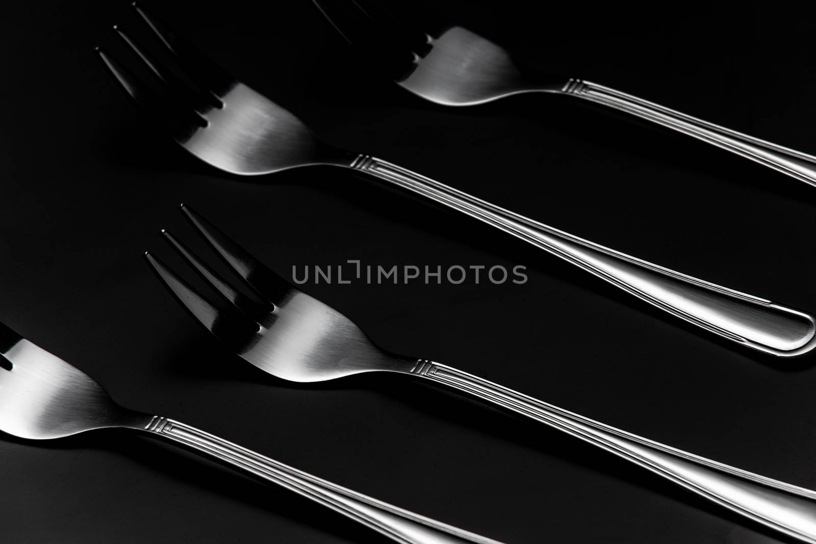 Silver Forks in Row on Dark Background. Low Kay Noir Image. Stil by merc67