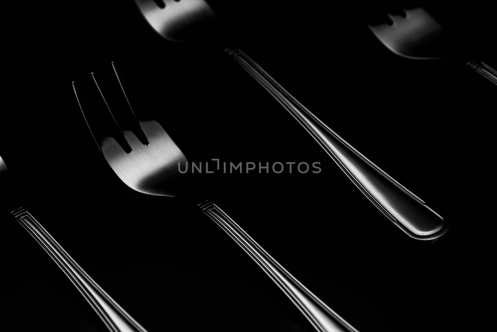 Steel or Silver Forks in Patter. Low Key Dark Image with Shiny Fork Silhouette. Flat Lay Still Life.