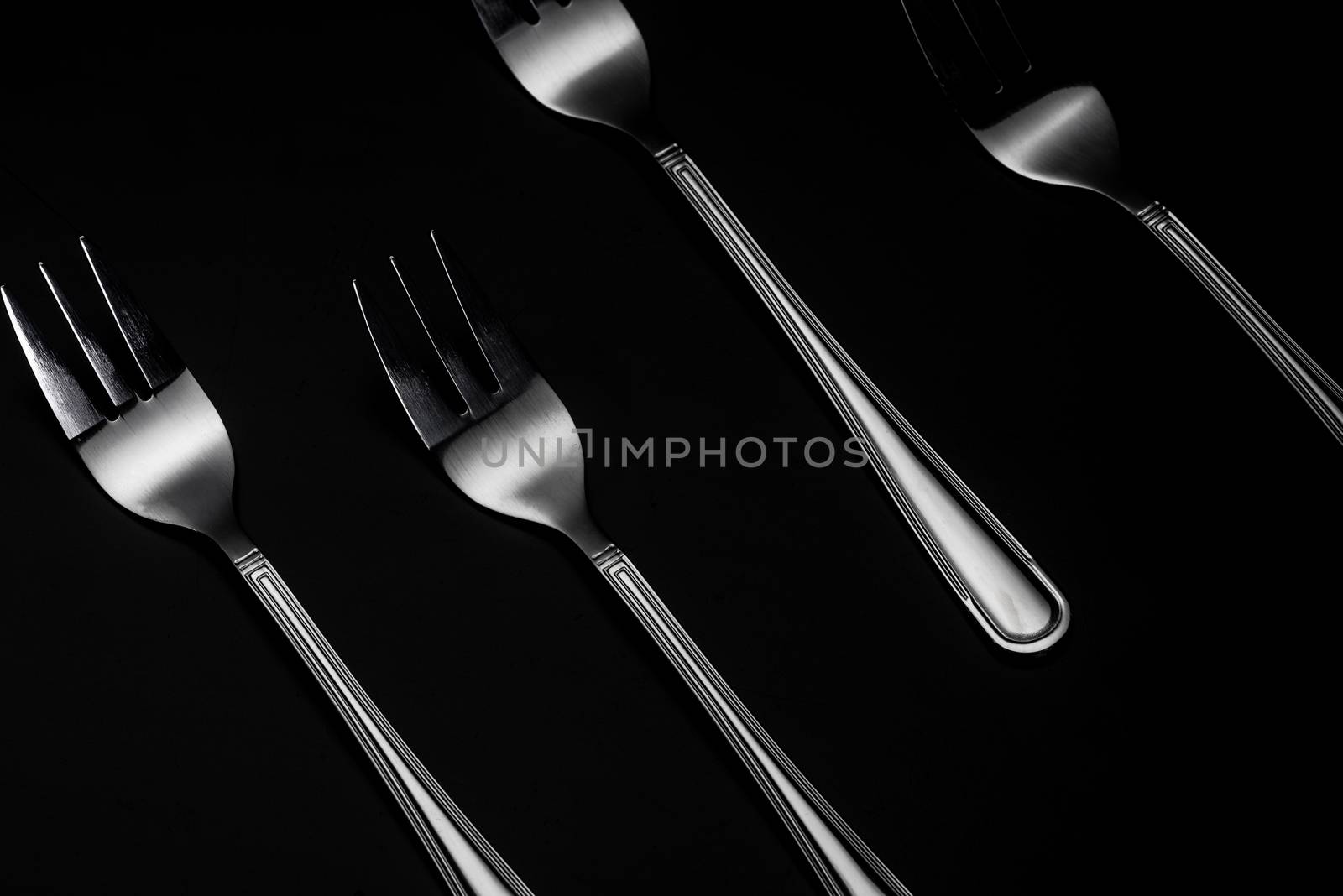 Silver Forks in Row on Dark Background. Low Kay Noir Image. Stil by merc67
