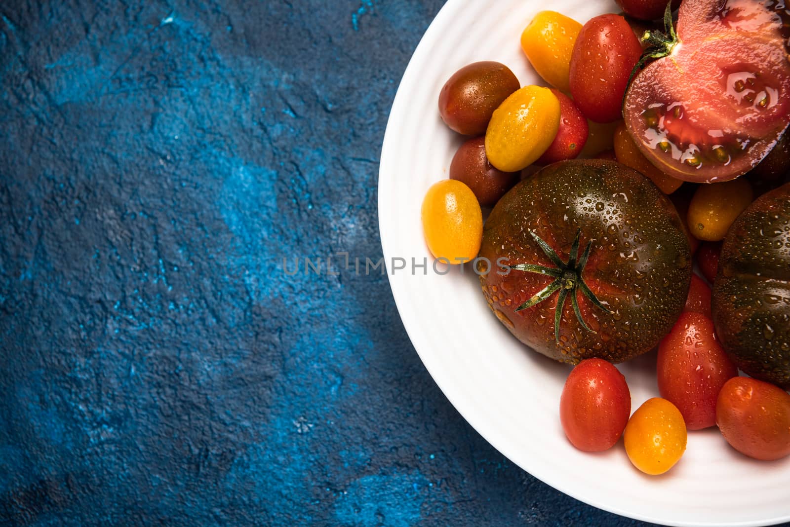 Vibrant Organic Tomatoes on Plate. Market Fresh Vegan Food. Plant Food Diet.