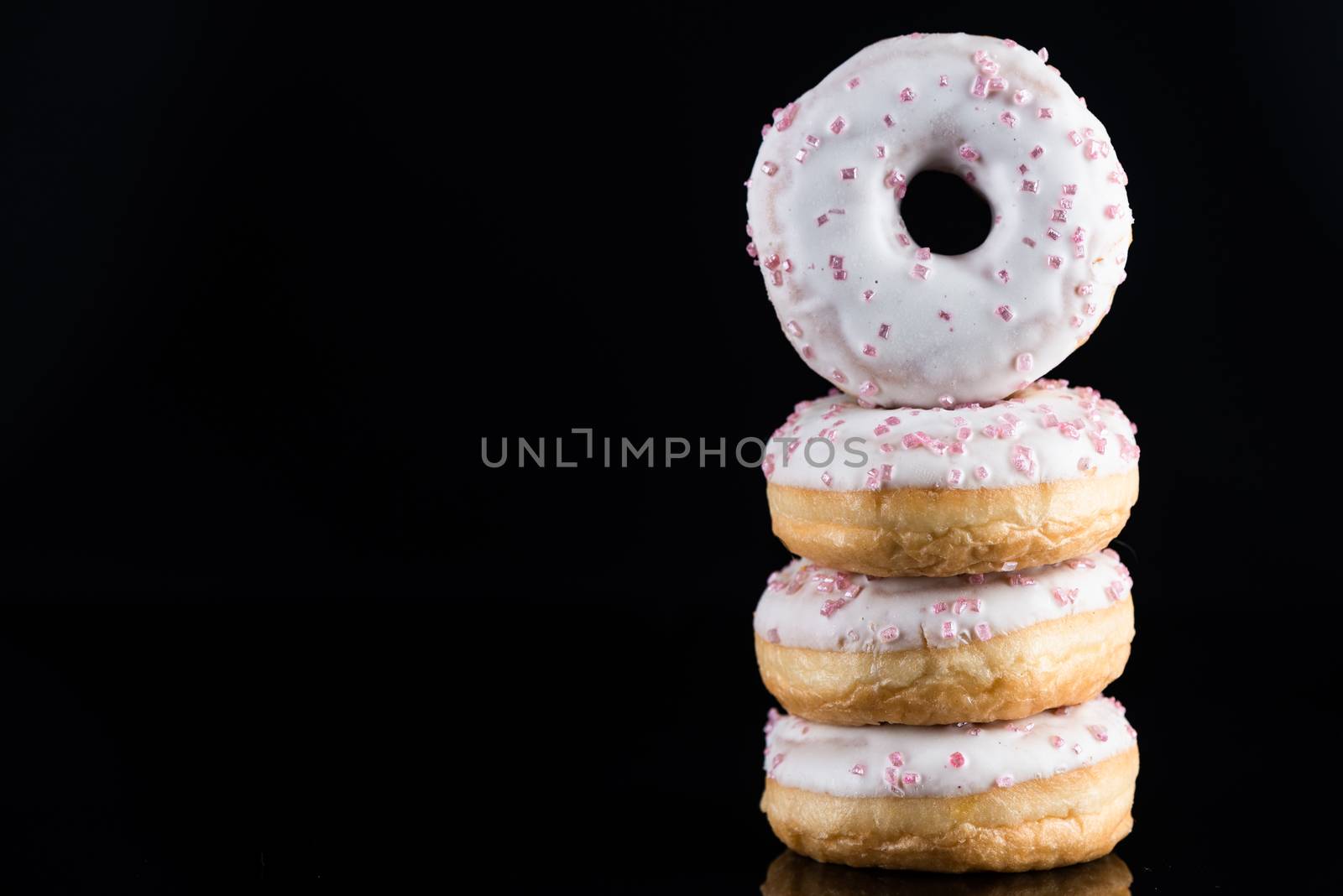 White Chocolate Donuts or Doughnuts Tower on Dark Background. Co by merc67