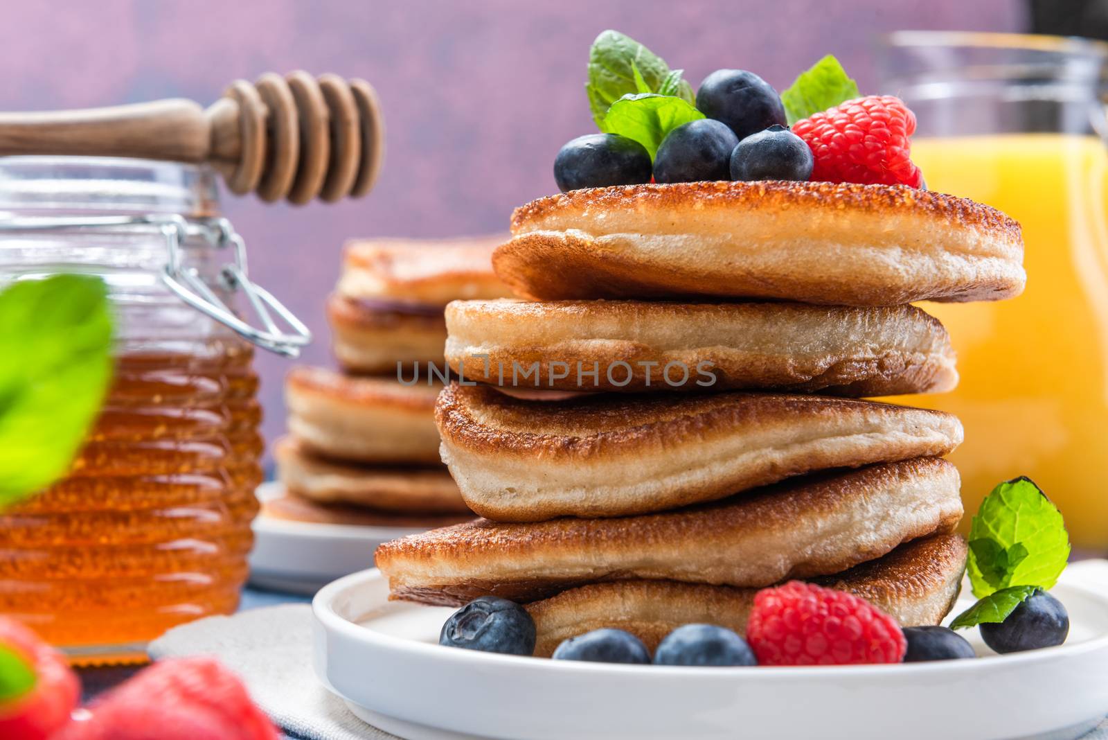 American Pancakes Served with Fresh Berry Fruits and Honey. Shrove Tuesday.