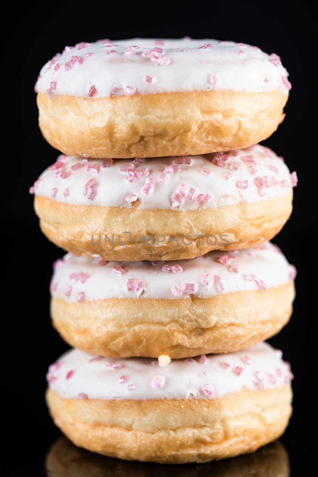 White Chocolate Donuts or Doughnuts Tower on Dark Background .