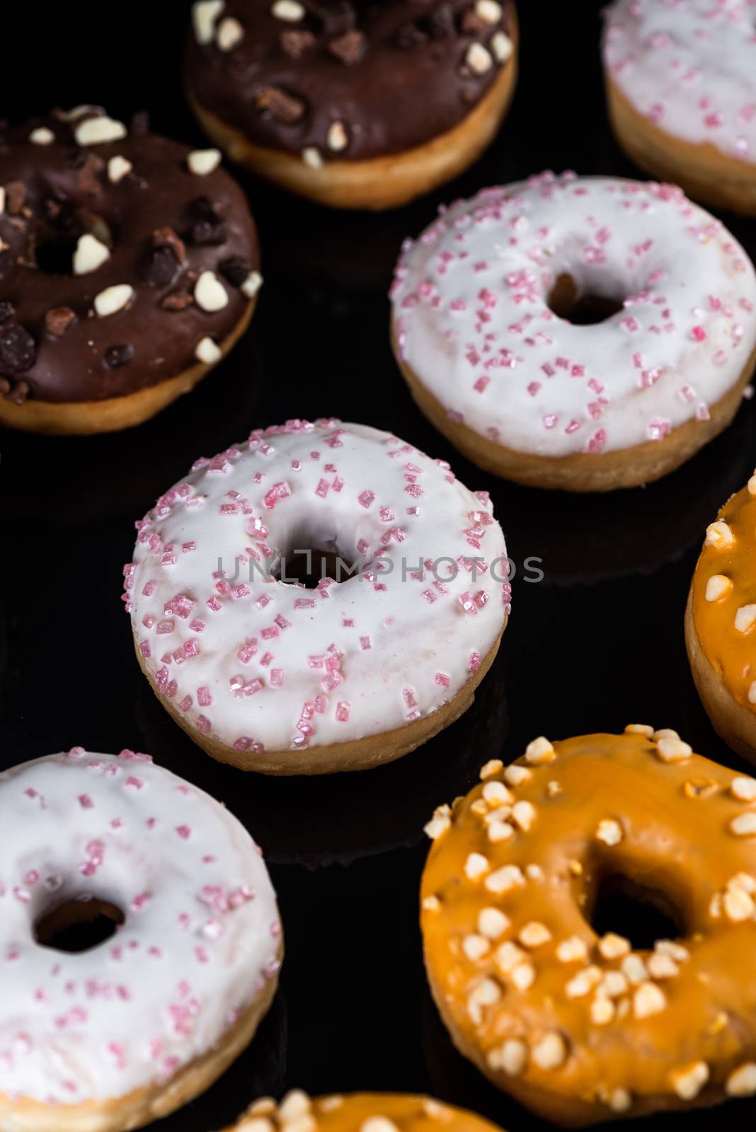 Decorated Donuts or Doughnuts Flat Lay on Dark Background by merc67