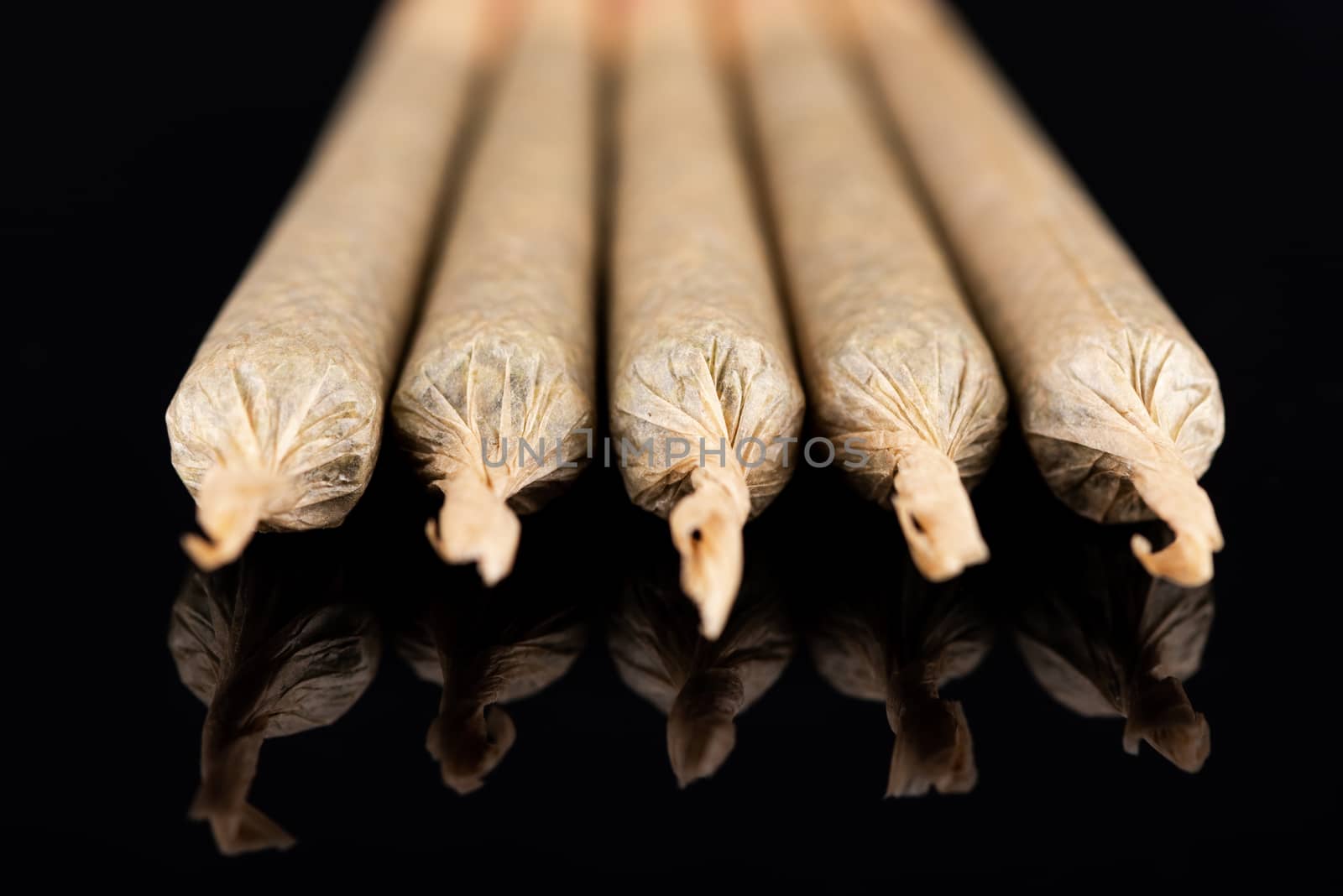 Cannabis Marijuana Rolled in Joints on Dark Reflective Backgroun by merc67
