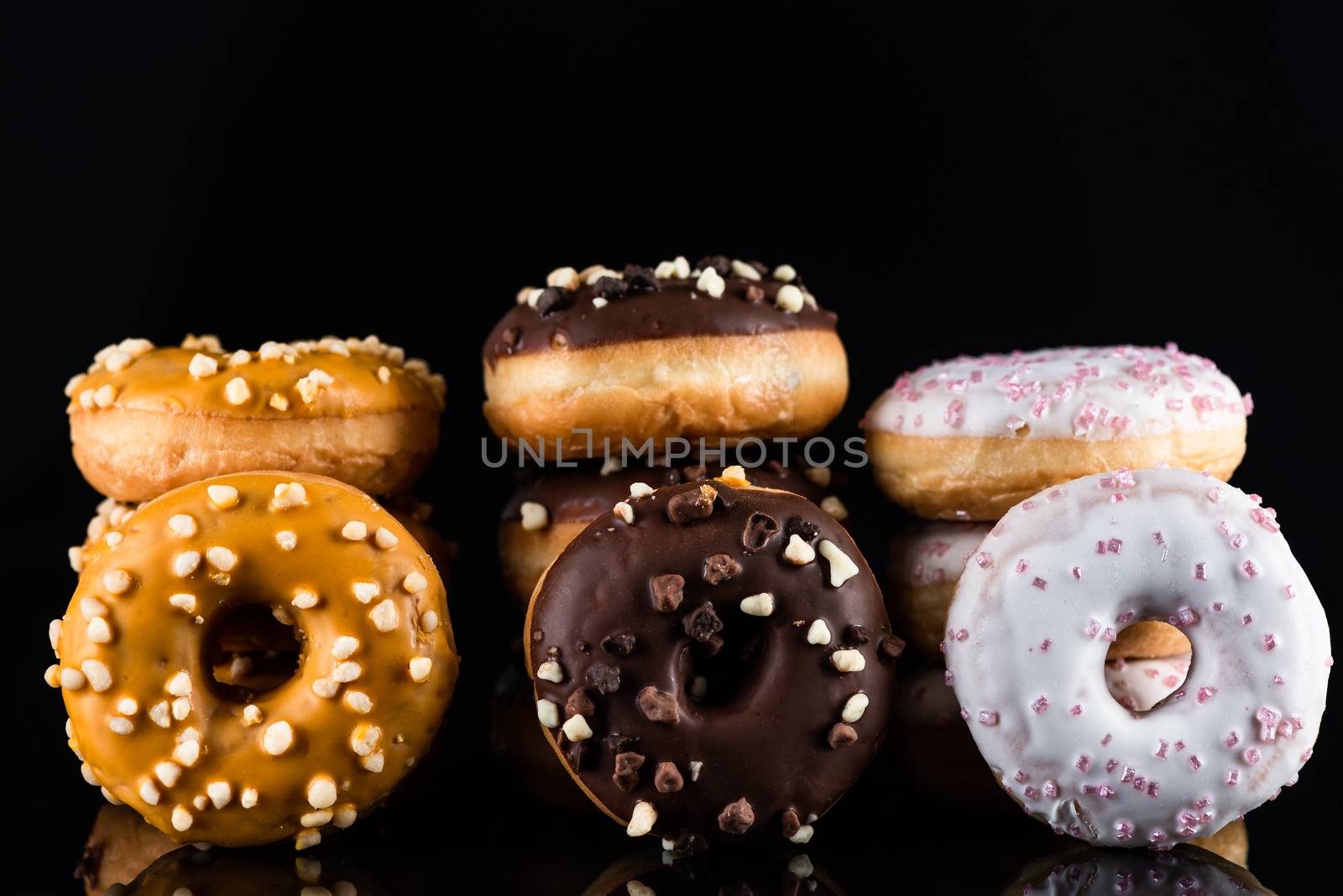 Donuts or Doughnuts Tower on Dark Background. Donut Stack Pile Food Background.