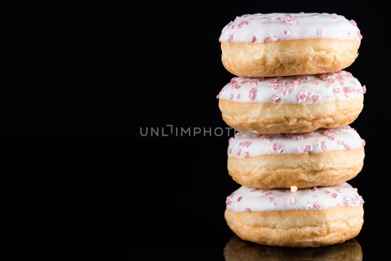 White Chocolate Donuts or Doughnuts Tower on Dark Background .