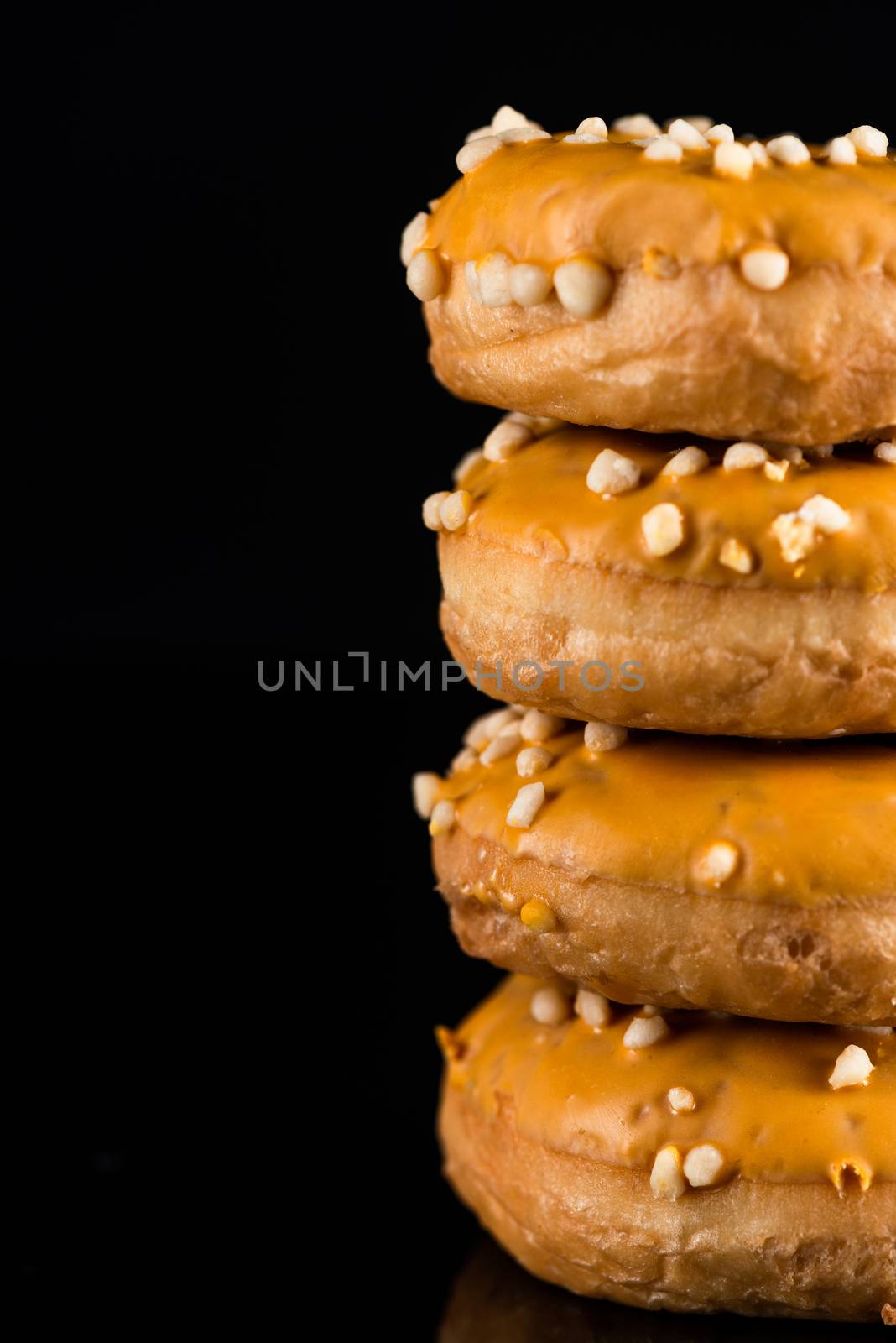 Salted Caramel Donuts or Doughnuts Tower on Dark Background. Copy Space for Text.