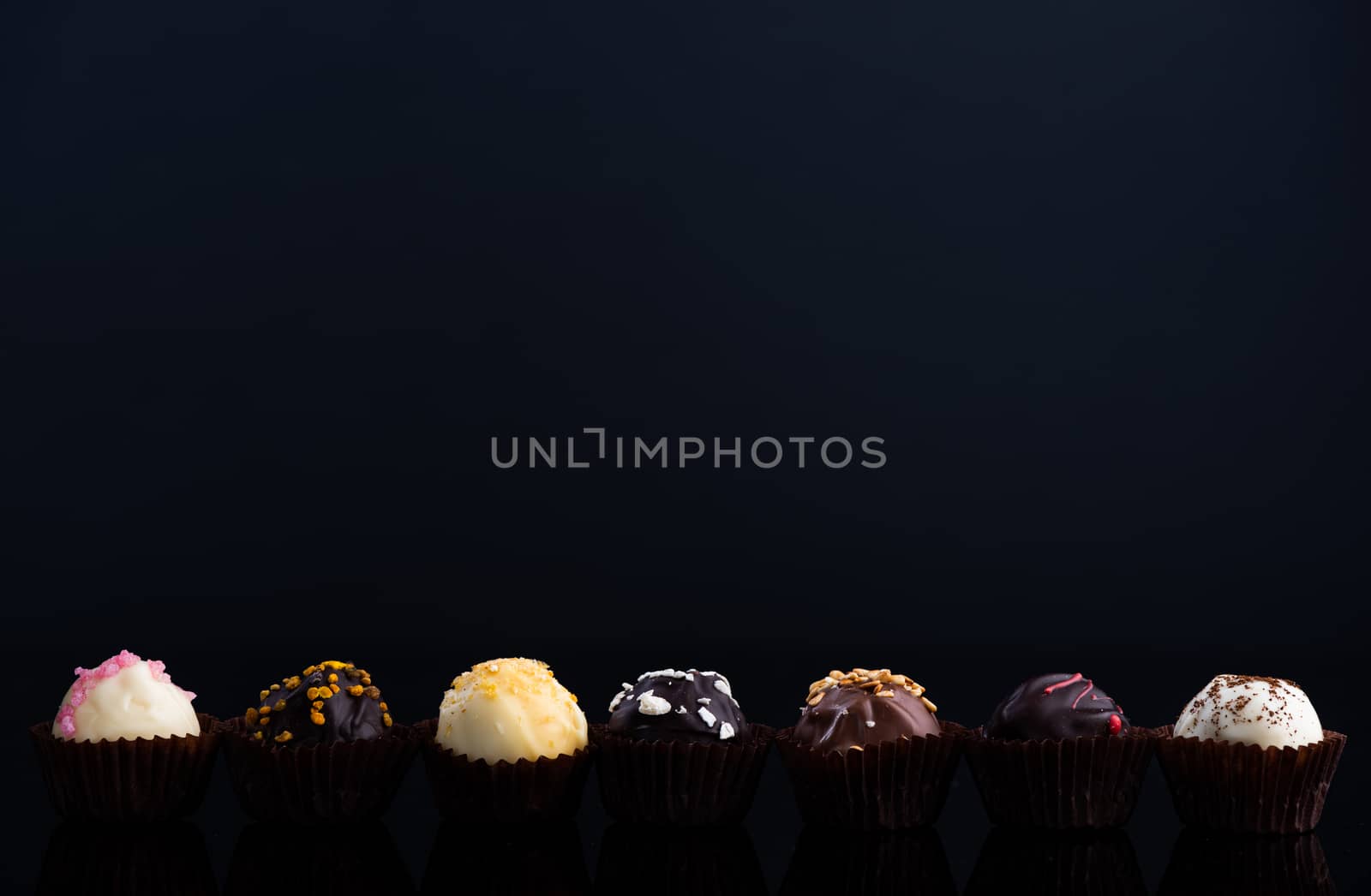 Chocolate Pralines on Dark Background. Copy Space for Text. Close Up Detail View.