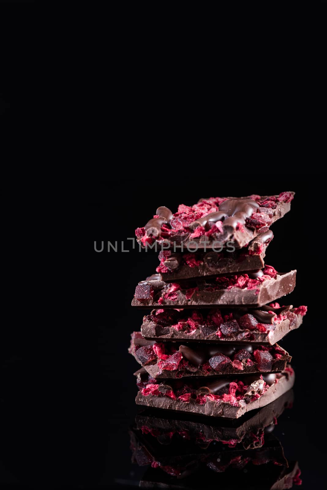 Stack of Broken Chocolate Pieces on Black Background. Copy Space by merc67