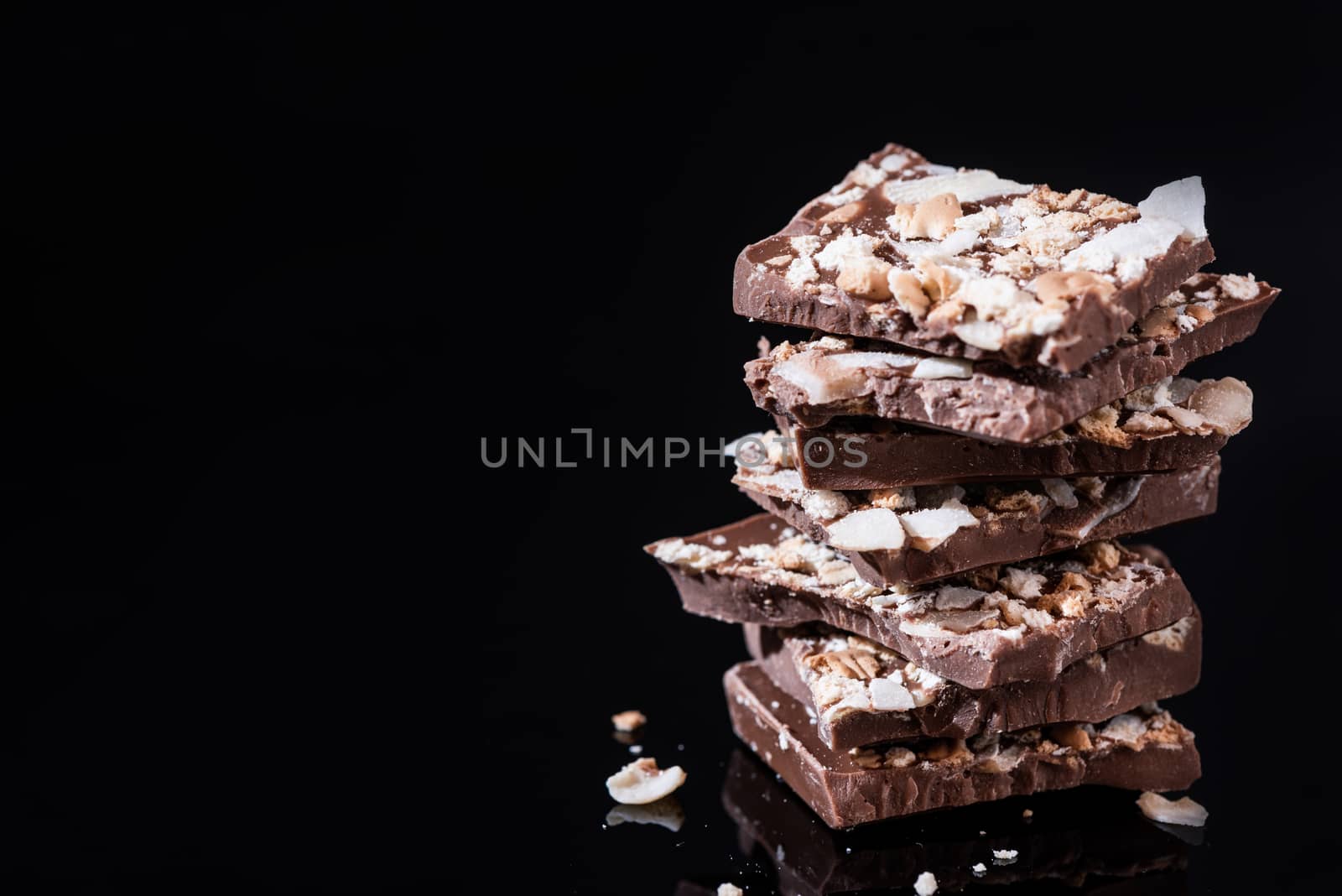 Stack of Broken Chocolate Pieces on Black Background. Copy Space by merc67