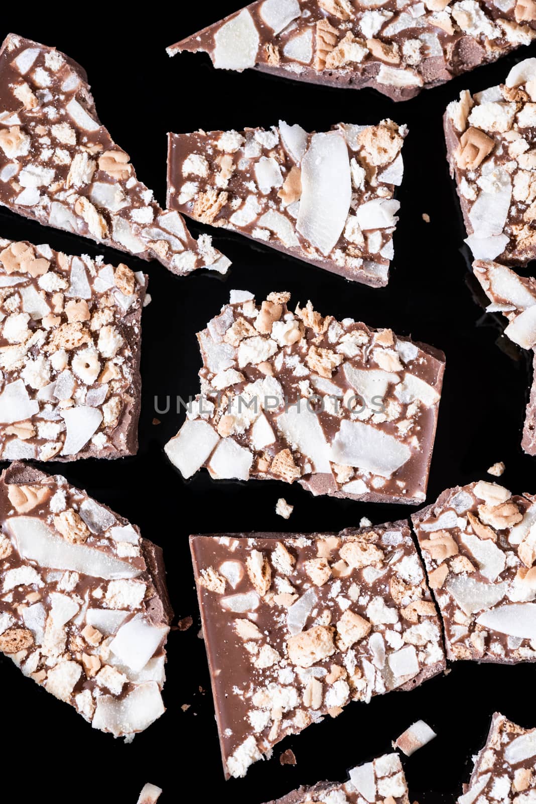 Broken Pieces of Chocolate Bar on Dark Background. Close Up View by merc67