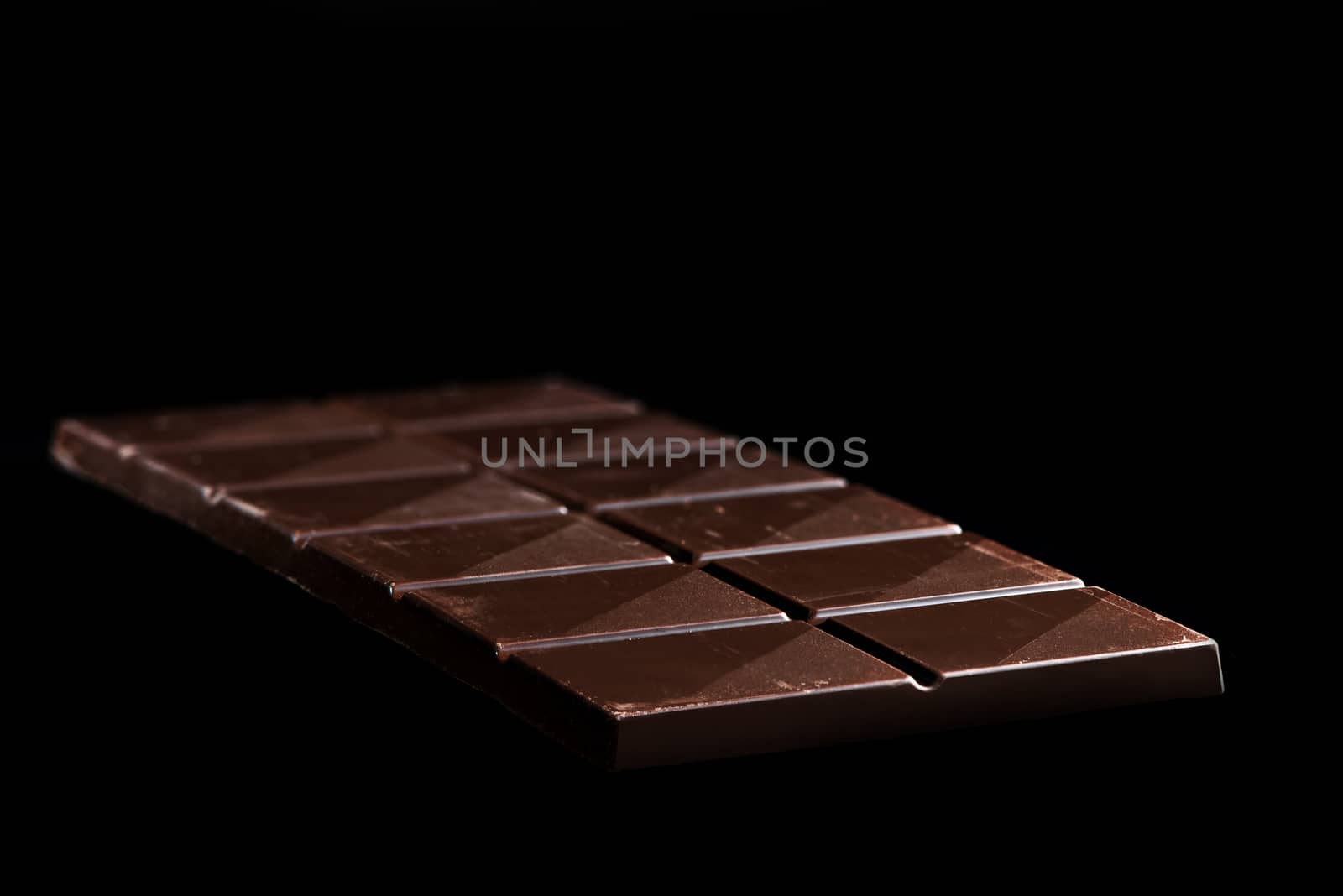 Chocolate Whole Bar on Black Background. Closeup View.