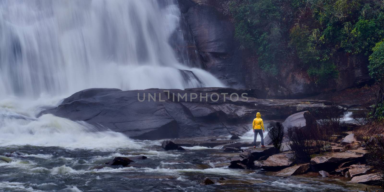 Woman standing at the base of High Falls . by patrickstock