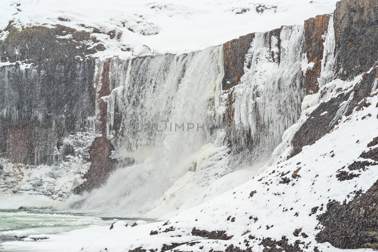 Snaedufoss waterfall during a snowing winter day, Iceland