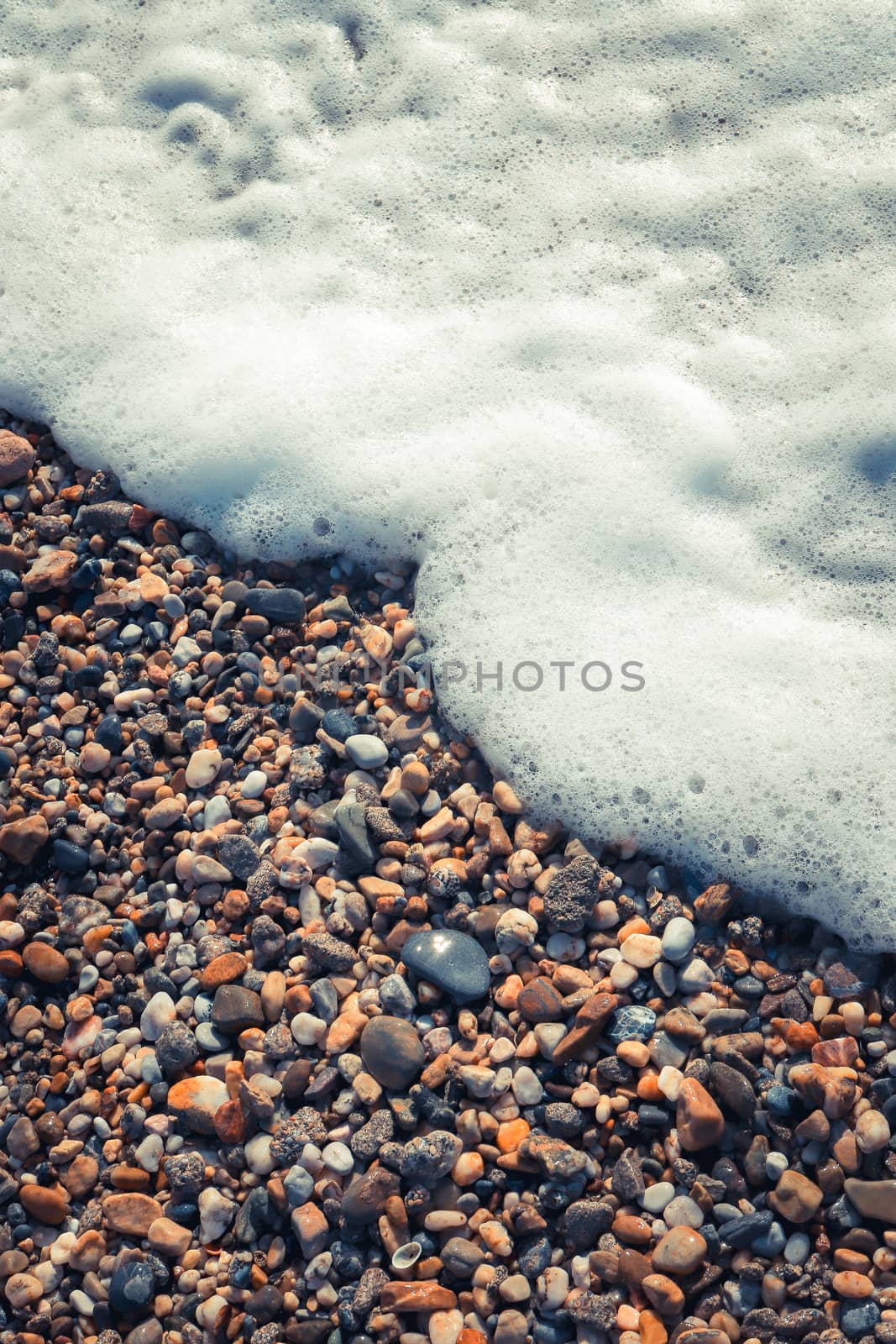 Sea water foam on the beach stones. Nautical marine summer backg by sanches812