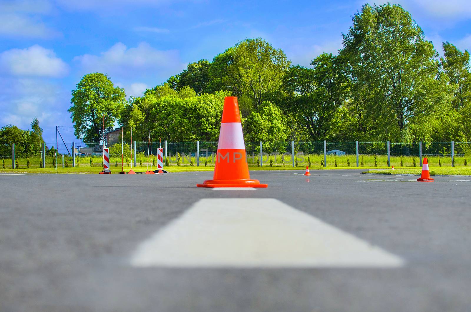 Traffic cone standing on dark asphalt. by KajaNi