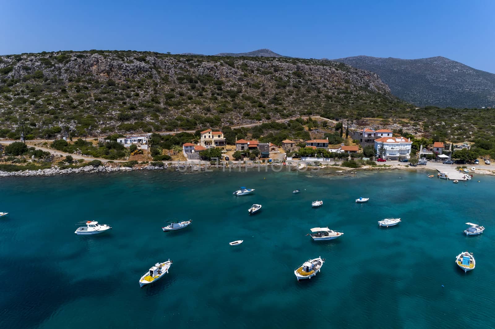 Aerial photo view of small traditional fishing boats in tropical emerald and turquoise clear sea. Peloponnese, Greece