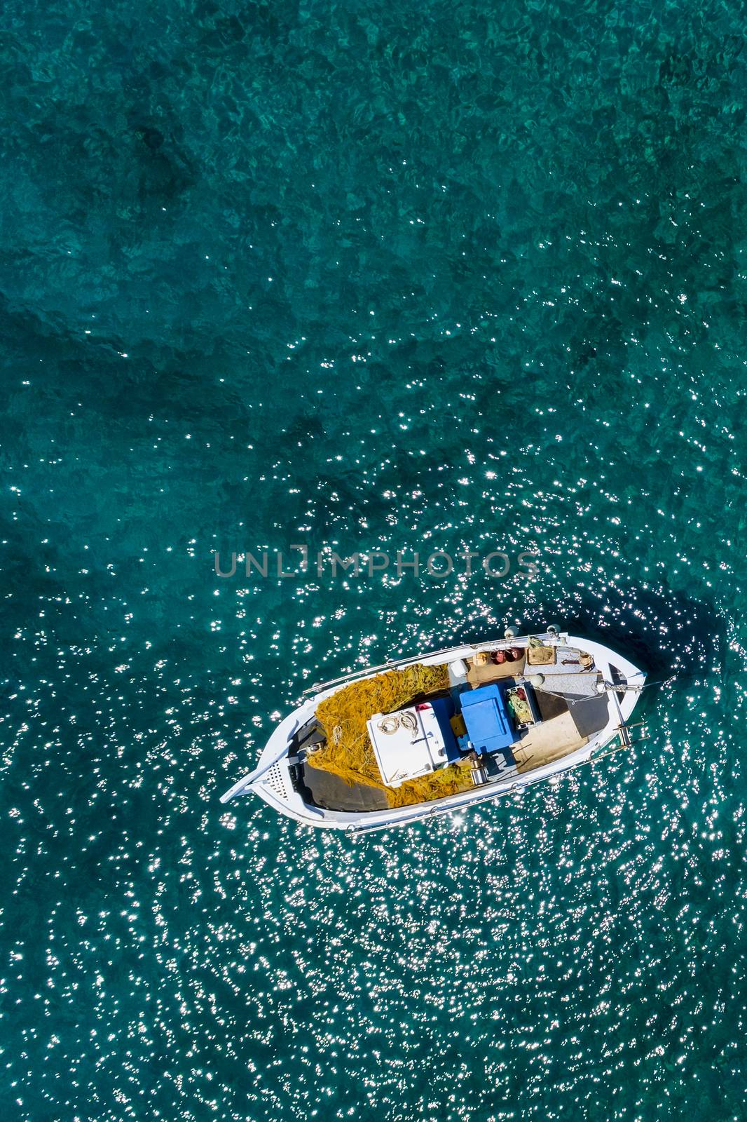 Aerial photo top view of small traditional fishing boat in tropi by ververidis