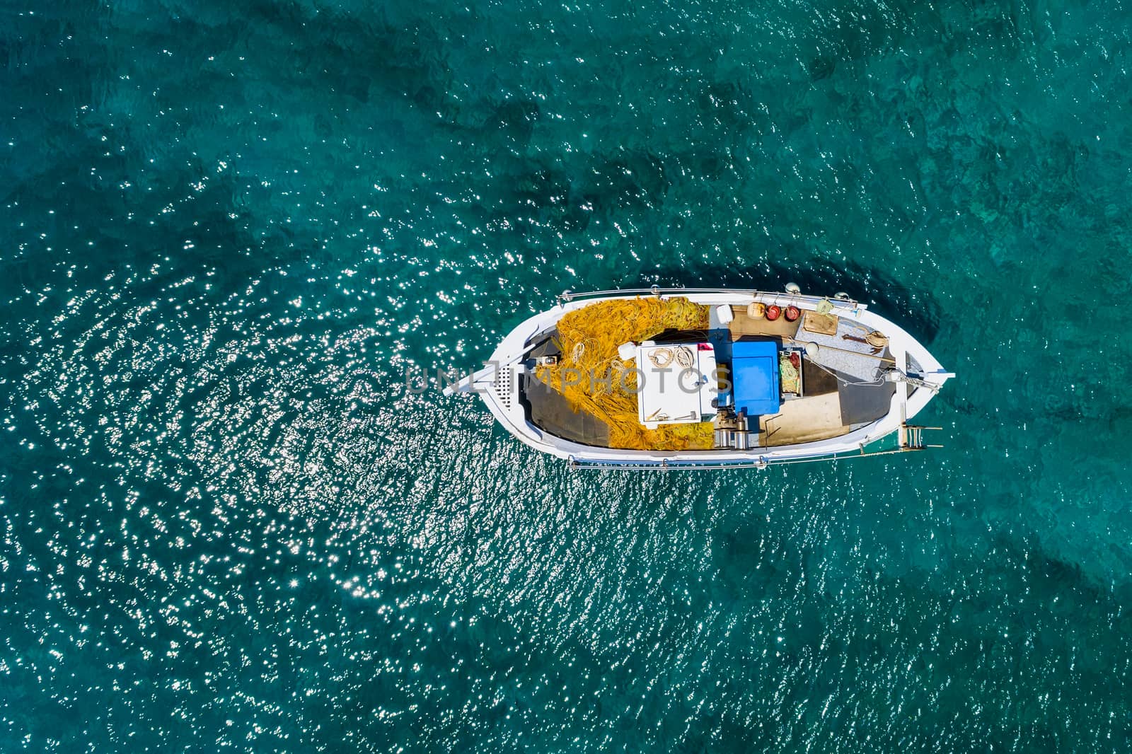 Aerial photo top view of small traditional fishing boat in tropi by ververidis