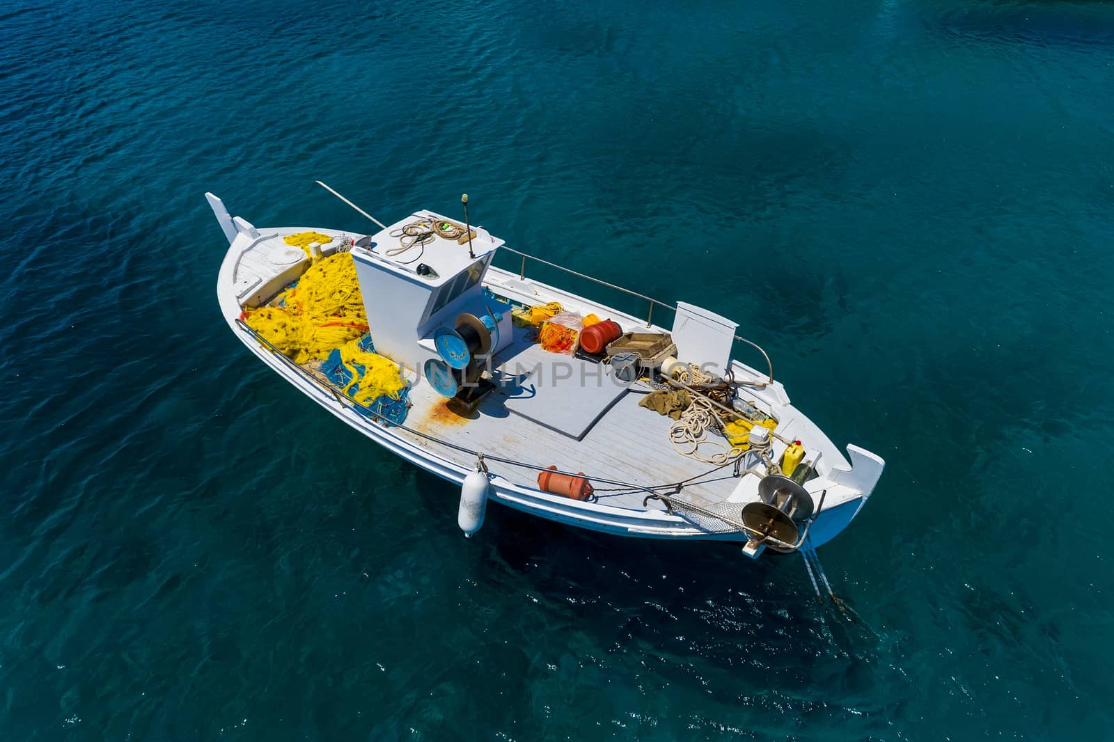 Aerial photo top view of small traditional fishing boat in tropi by ververidis