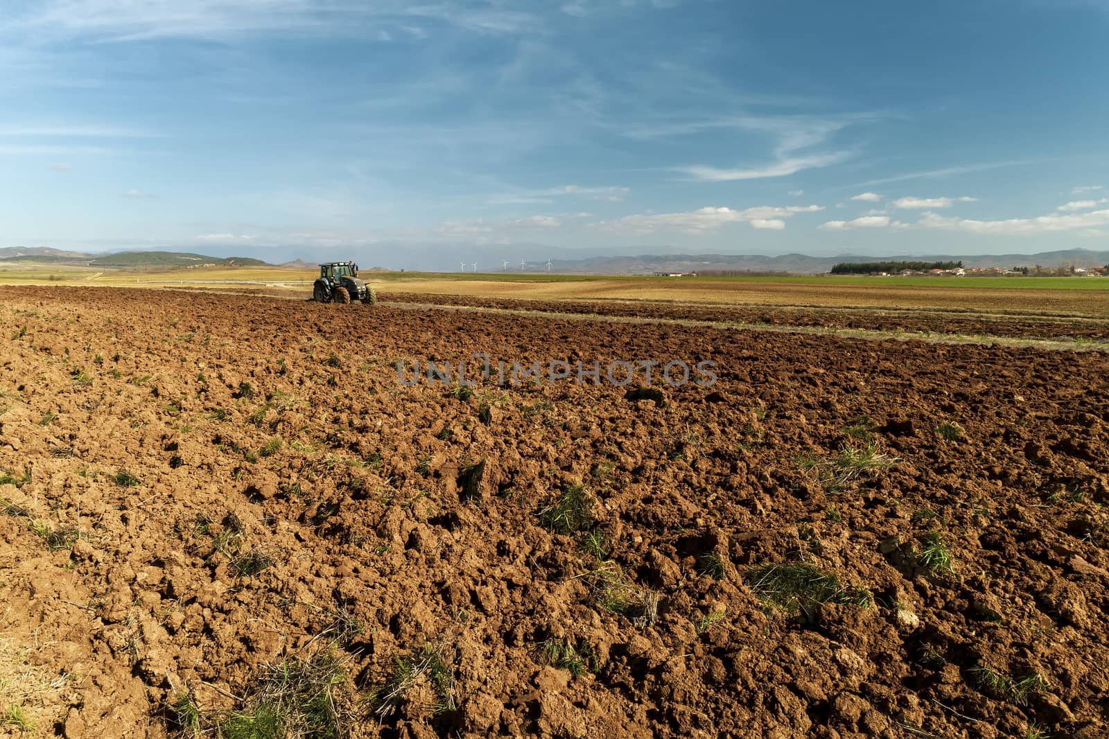 aerial view of the tractor plows in the field, by ververidis