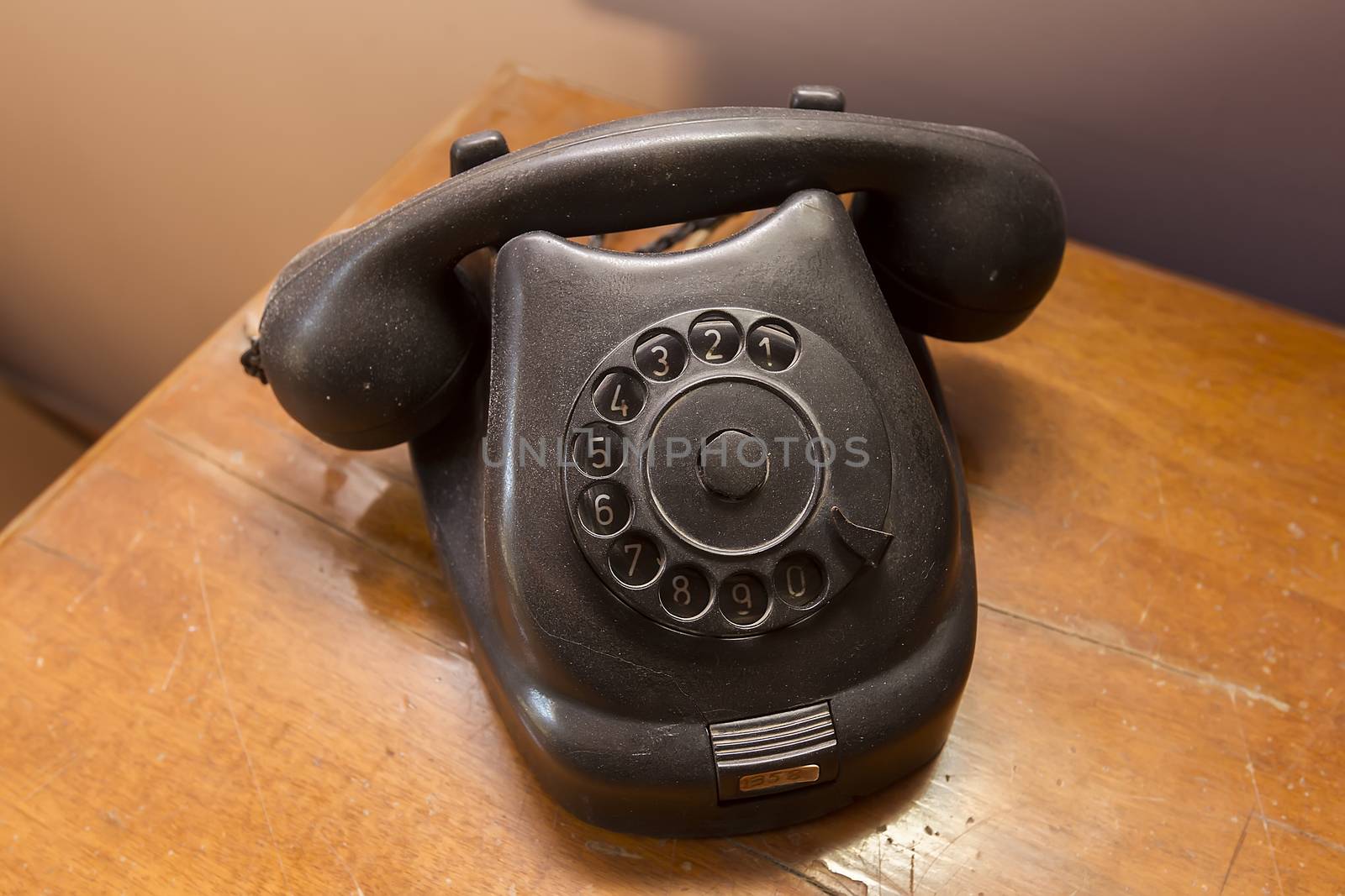 Vintage black phone on old wooden table background by ververidis