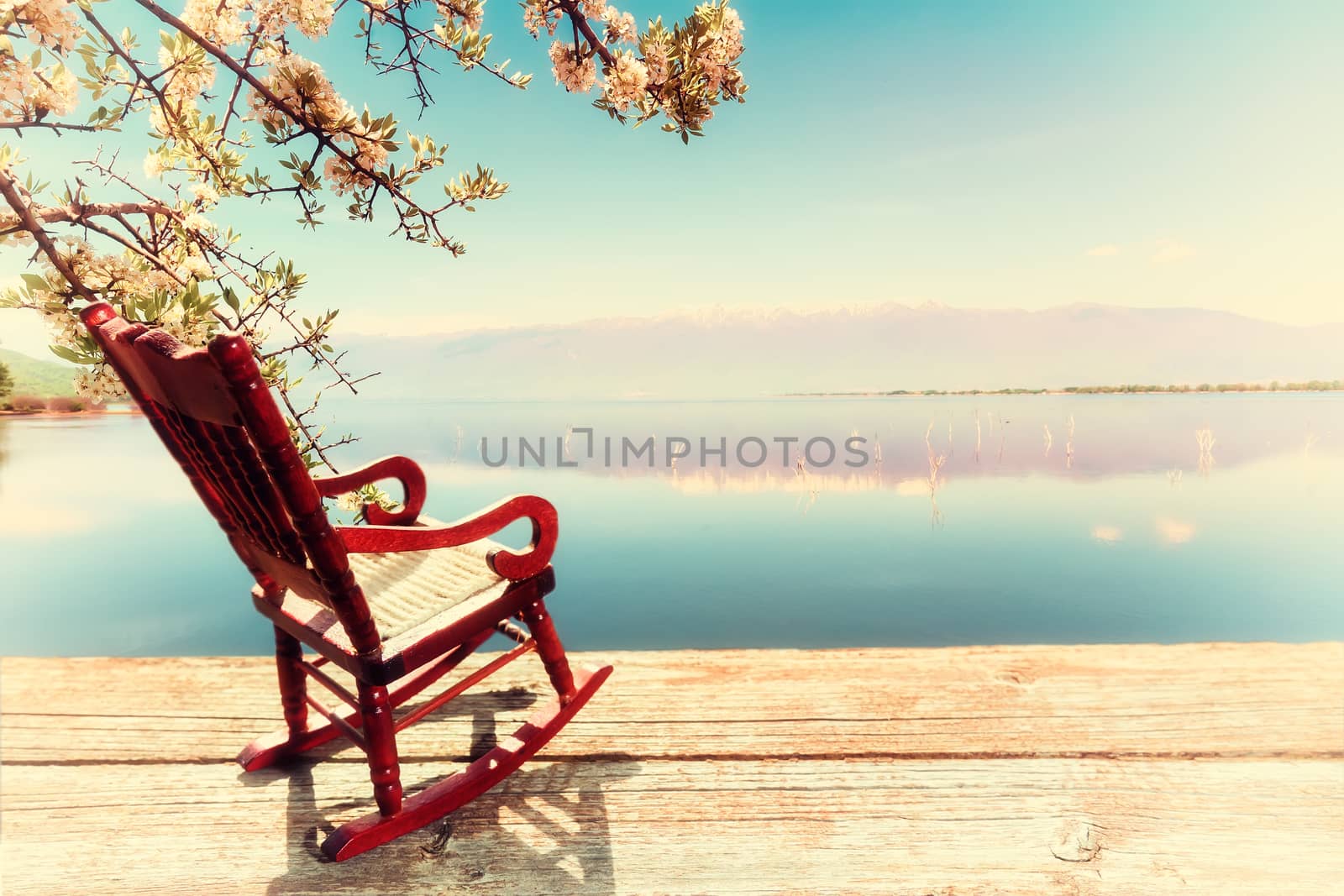 Miniature of a Rocking Chair in front of a lagoon, symbolizing relaxation at the beach. image cross processed for vintage look